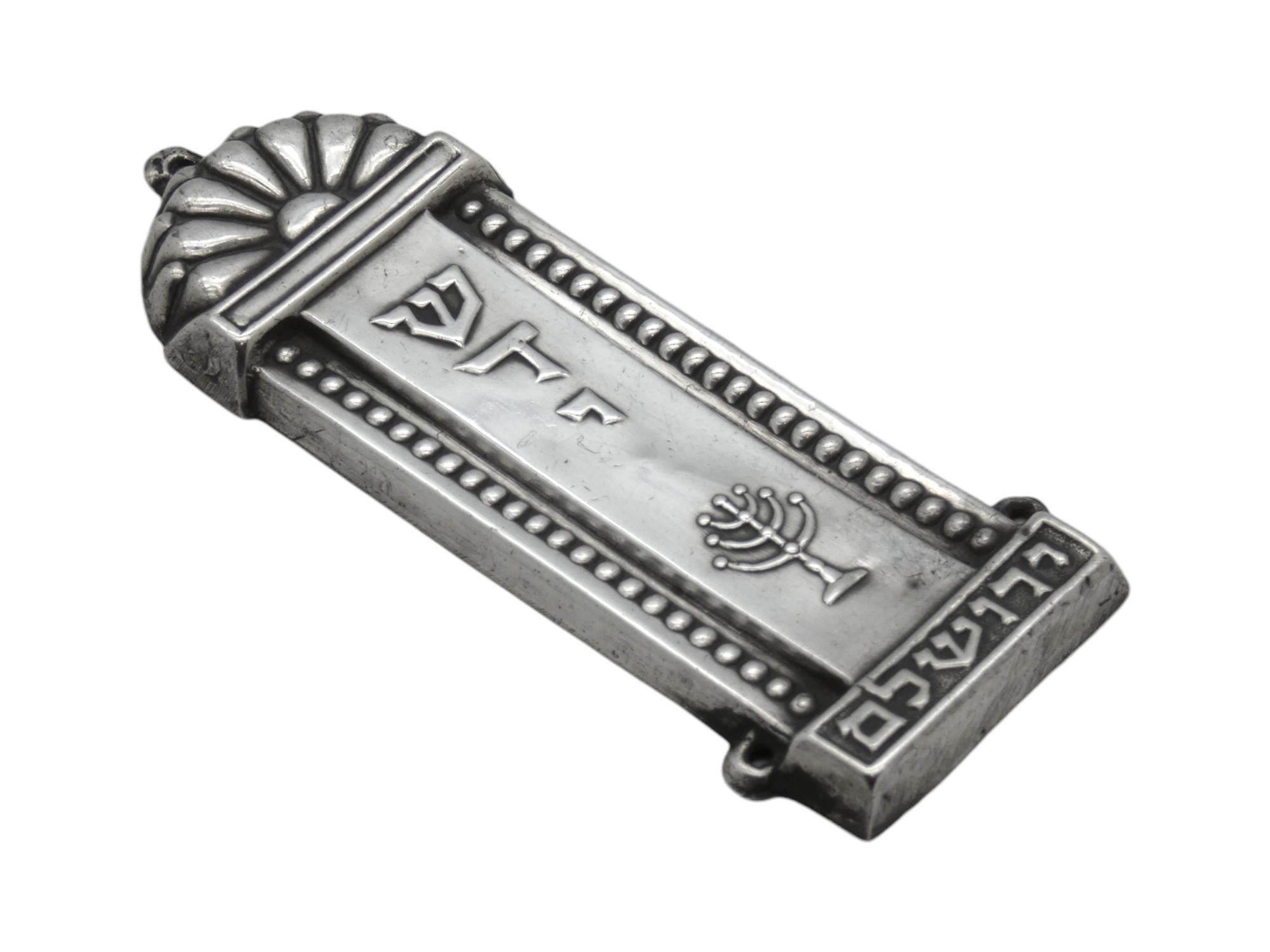 Un porta Mezuzah d'argento israeliano di Gerusalemme del 1950 circa incarna sia le tradizioni religiose che le fiorenti espressioni artistiche del neonato Stato di Israel. Quest'epoca fu caratterizzata da un mix di arte revivalista e influenze