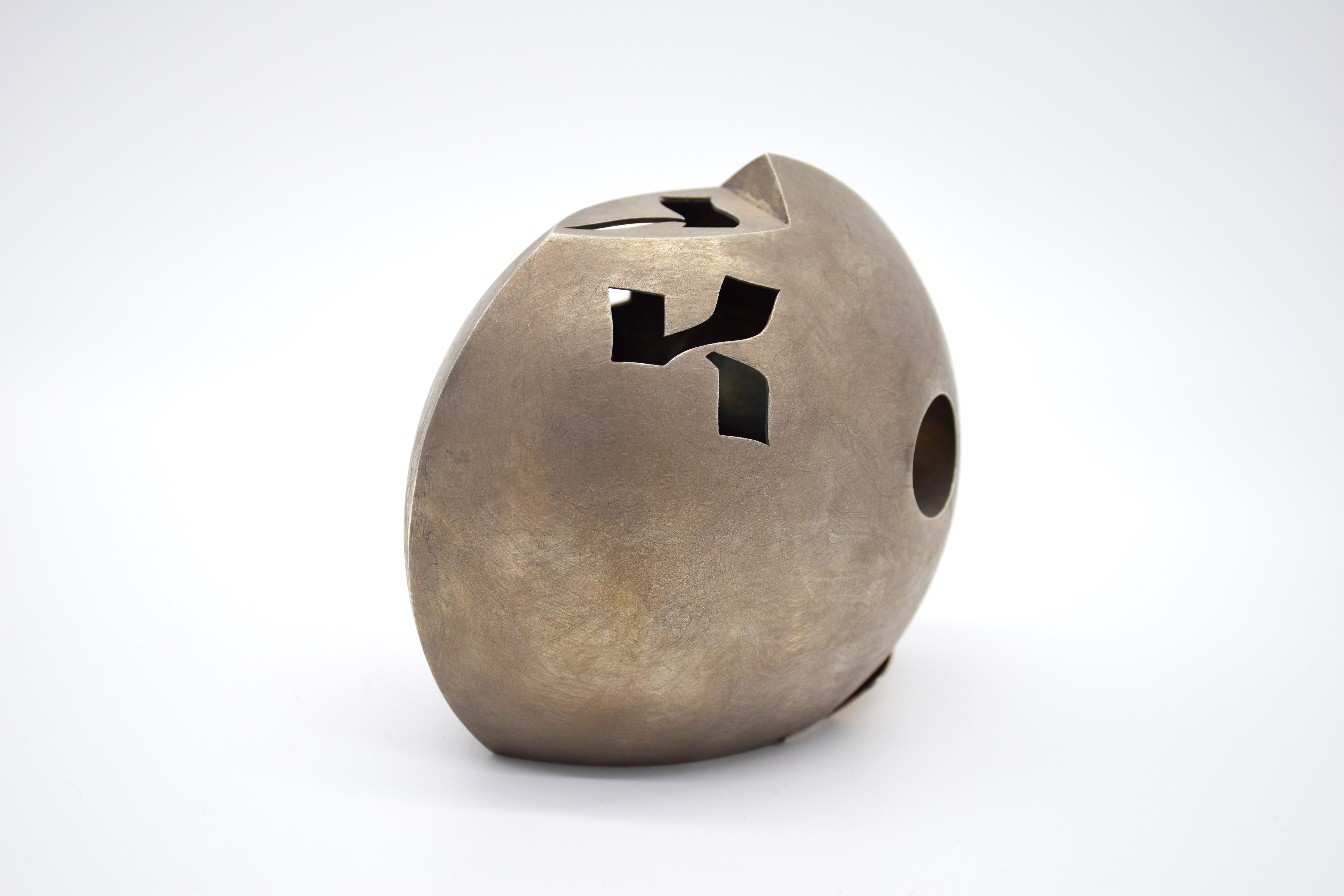 Tzedakah-Box in abgeflachter Eiform (runde Fischform), erstaunlich schlankes und modernistisches Design. einfach ein Meisterwerk des Designs.
Durchbohrt mit stilisierten hebräischen Worten für Charity oder 