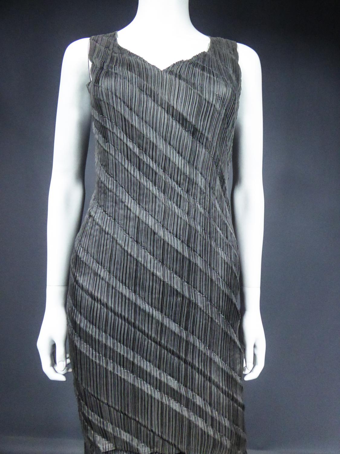 Early 1990
Japan

An Issey Miyaké top and skirt in charcoal grey pleated and goffered polyester from the early 1990's. Work of goffered pleats in oblique diagonal for this set with a straight and skin-tighted cut. Sleveless top with a