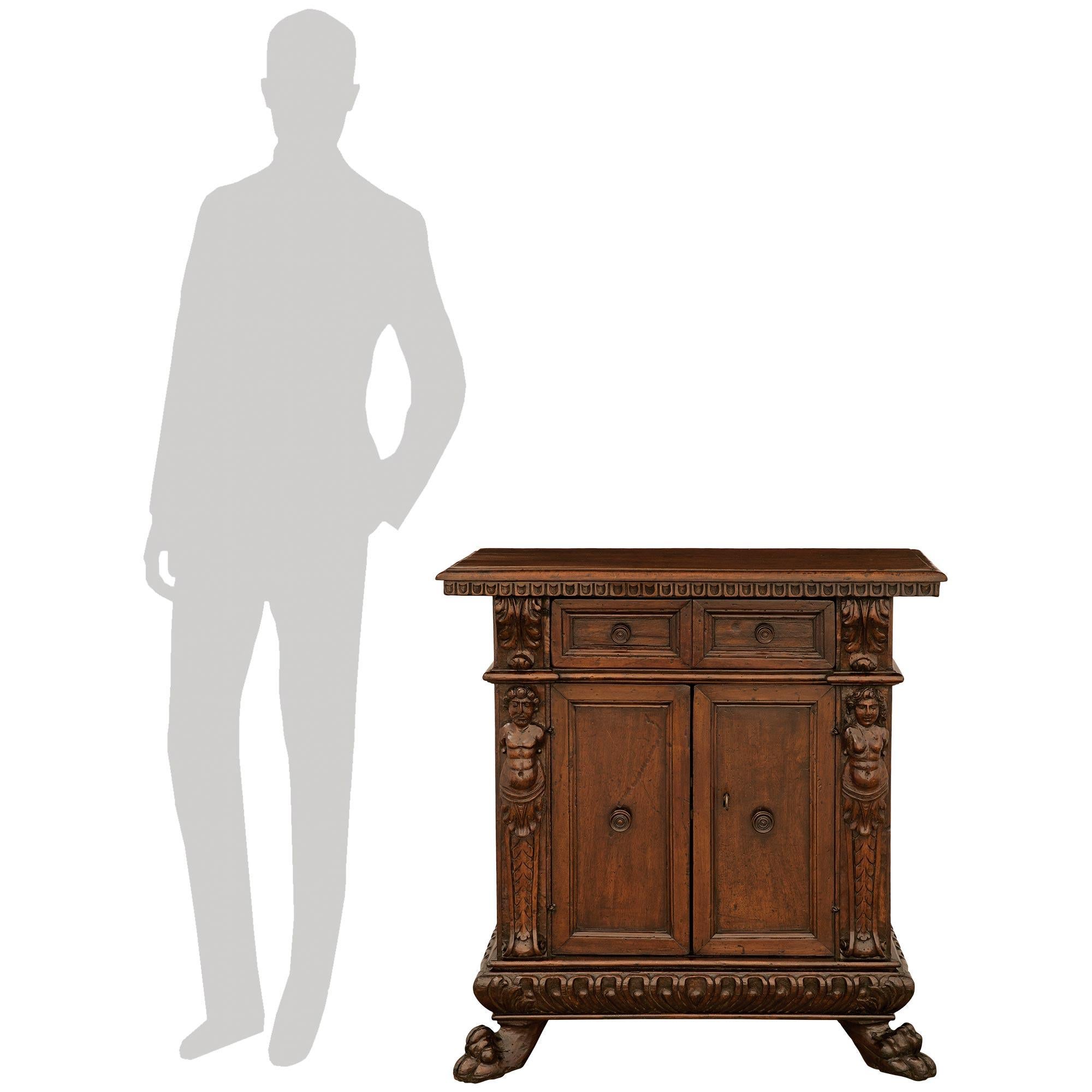 A handsome and most decorative Italian 17th century Baroque Period Walnut and Iron cabinet. This wonderful two door, two drawer cabinet is raised on impressive paw feet below a mottled border and the striking reeded gadroon frieze. At the center are