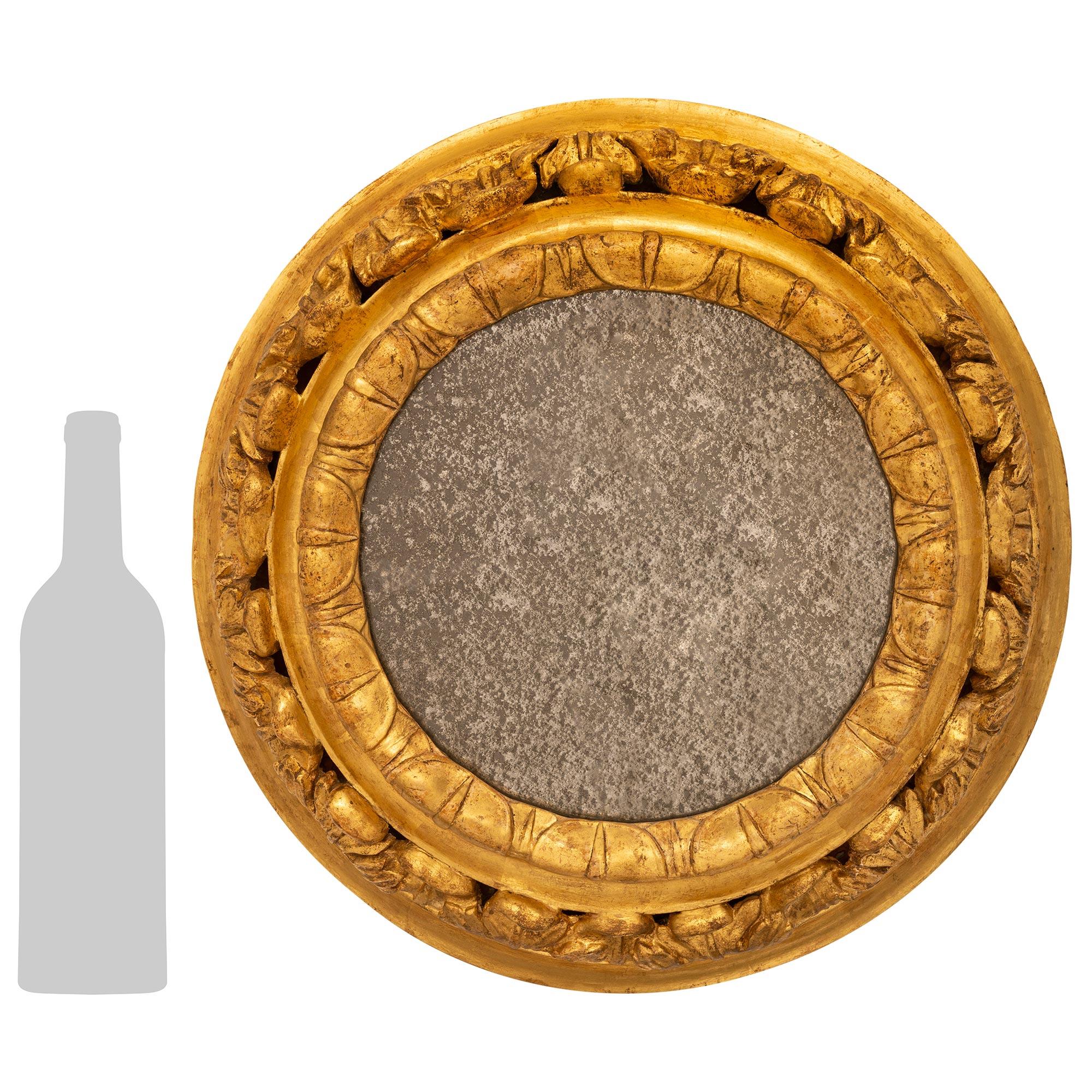 Miroir en bois doré d'époque baroque italienne du XVIIIe siècle, attrayant et très décoratif. Ce magnifique miroir circulaire contient sa plaque de miroir d'origine tandis que le cadre intérieur est orné d'un magnifique bandeau sculpté de