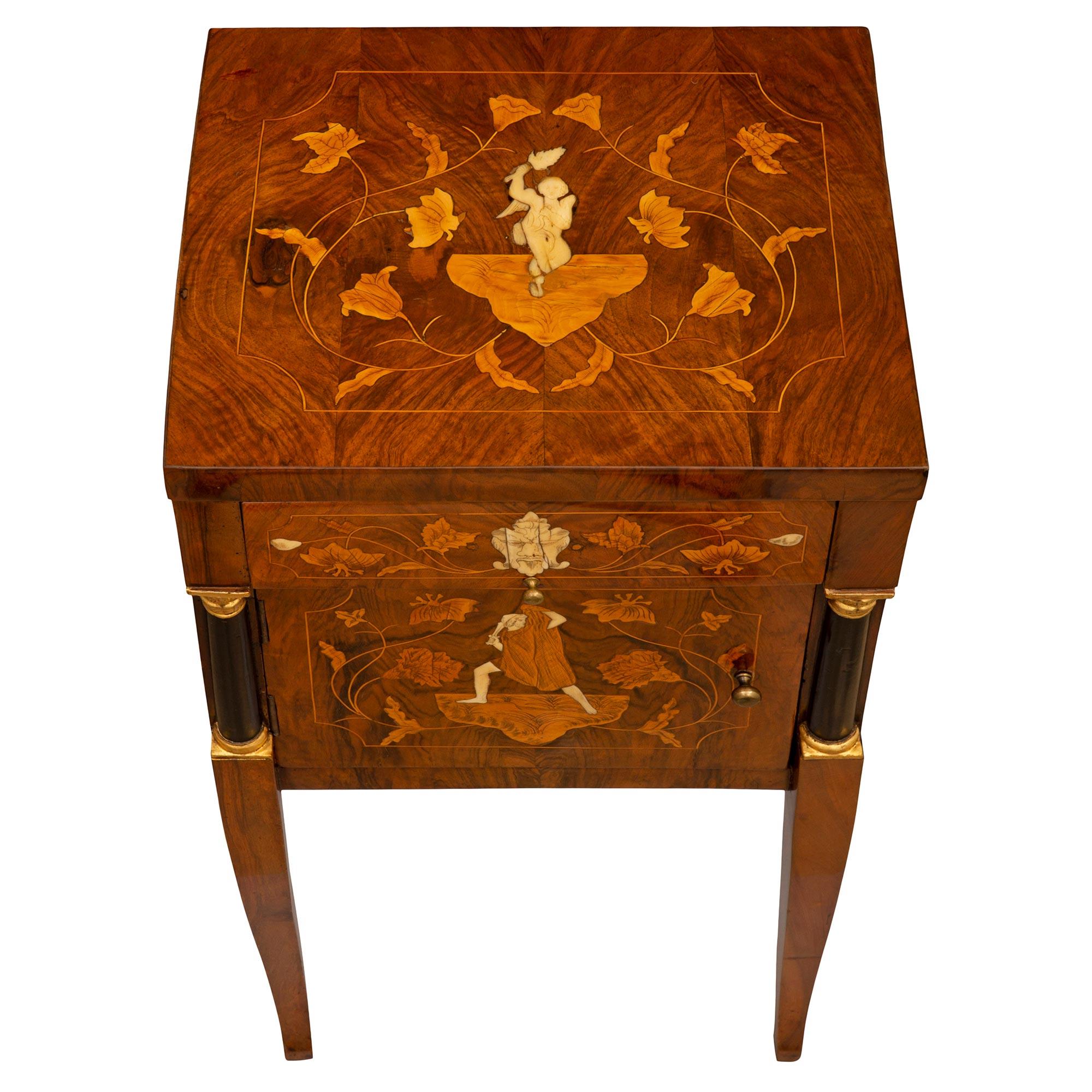 A striking and most decorative Italian 18th century Baroque period Walnut, Ebonized Fruitwood, giltwood, and bone side table. The one door, one drawer side table is raised by elegant lightly curved square tapered legs leading up to impressive