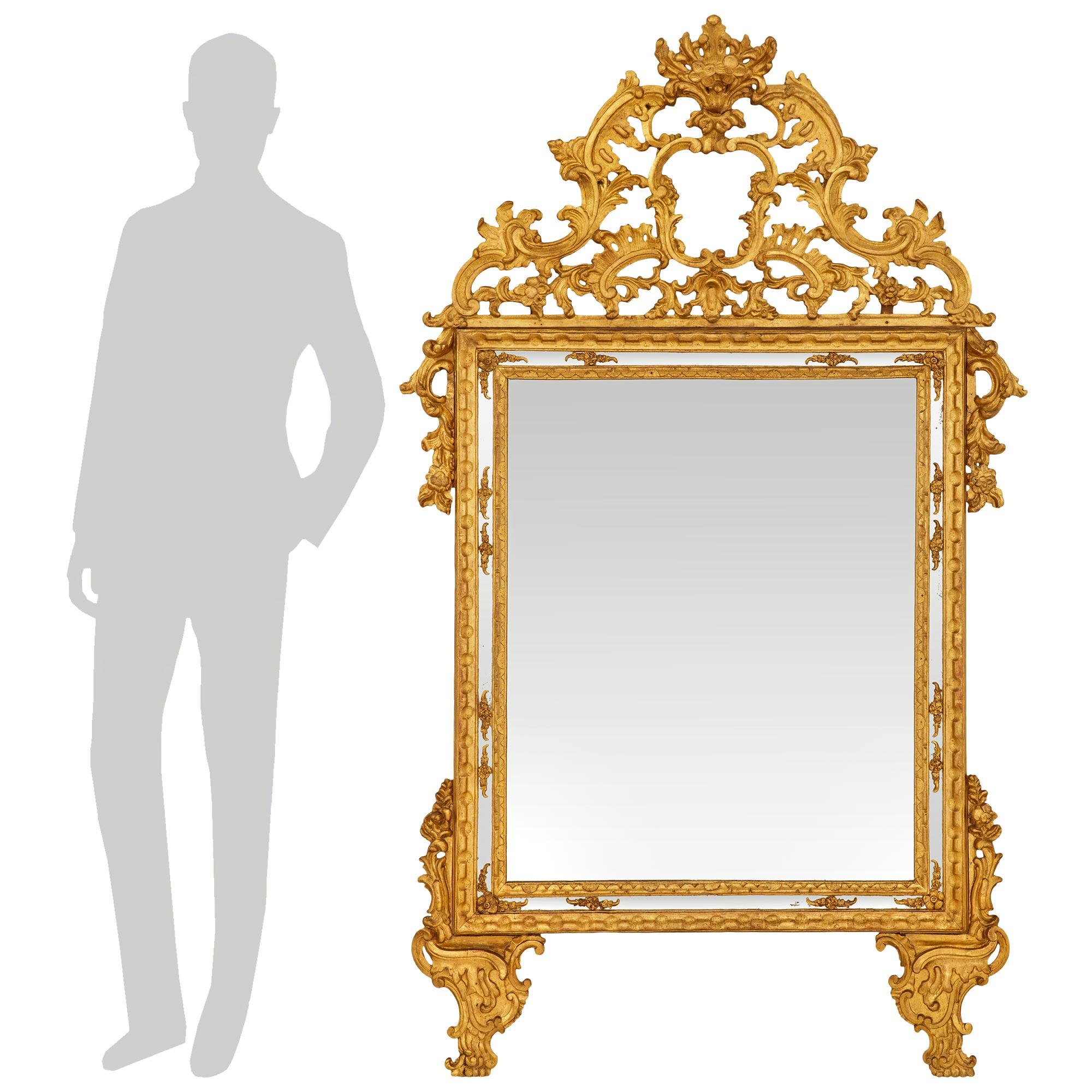 A high quality and most decorative Italian 18th century Louis XIV Period Giltwood mirror. This stunning double framed mirror, with original mirror plate, is raised on finely scrolled feet with foliate movements leading up the side. The mirror plate