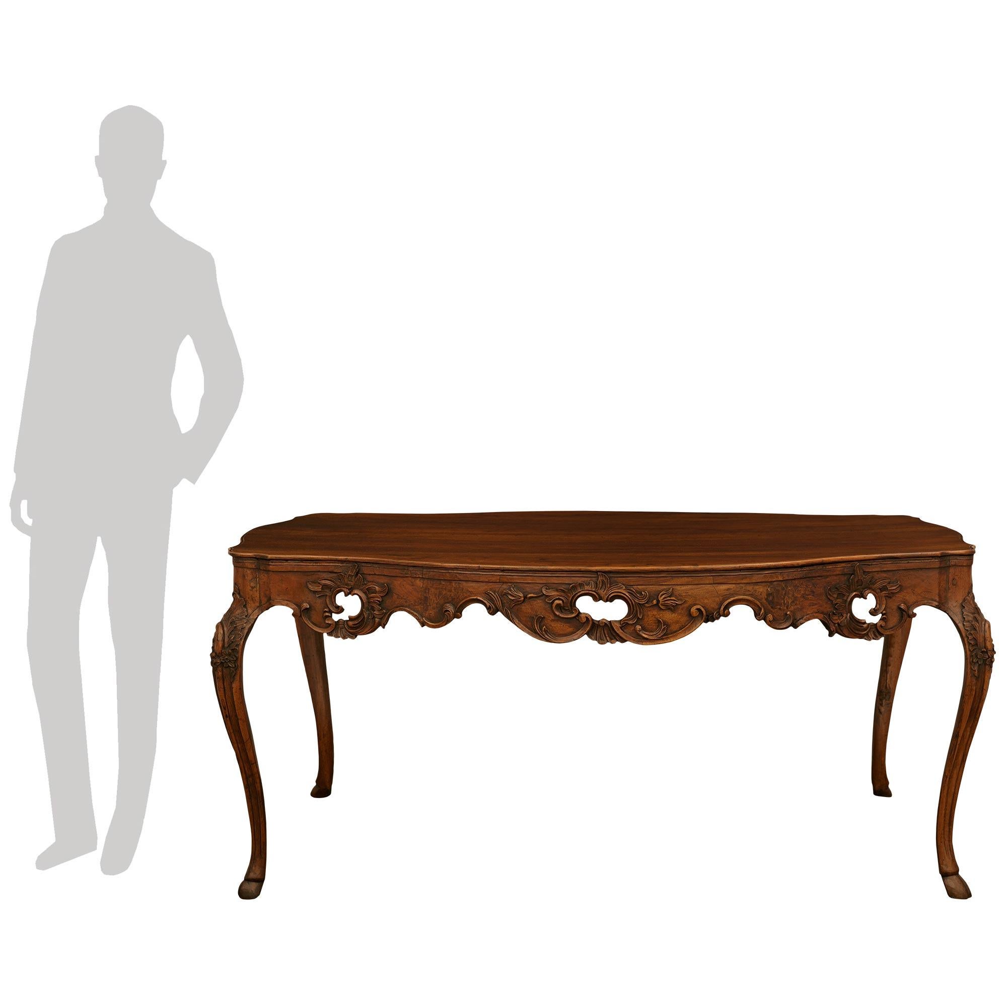 A handsome and most decorative Italian 18th century Louis XV Period Walnut dining table. This wonderful table is raised by elegant cabriole legs with fine hoof feet, and a decorative carved fillet below charming foliate and floral designs. The