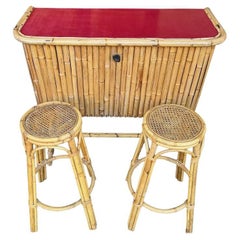 An Italian 1960s bamboo bar cabinet with red laminate top and two stools