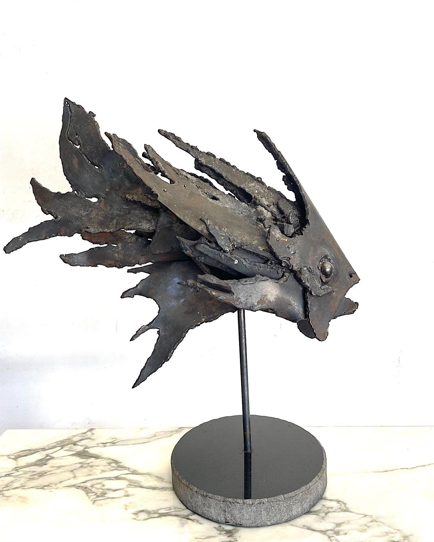 An Italian 1970s brutalist metal sculpture of a fish mounted on a black marble base.