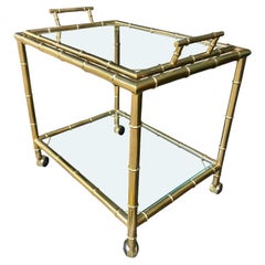 An Italian 1970s faux bamboo brass bar trolley with removable top tray