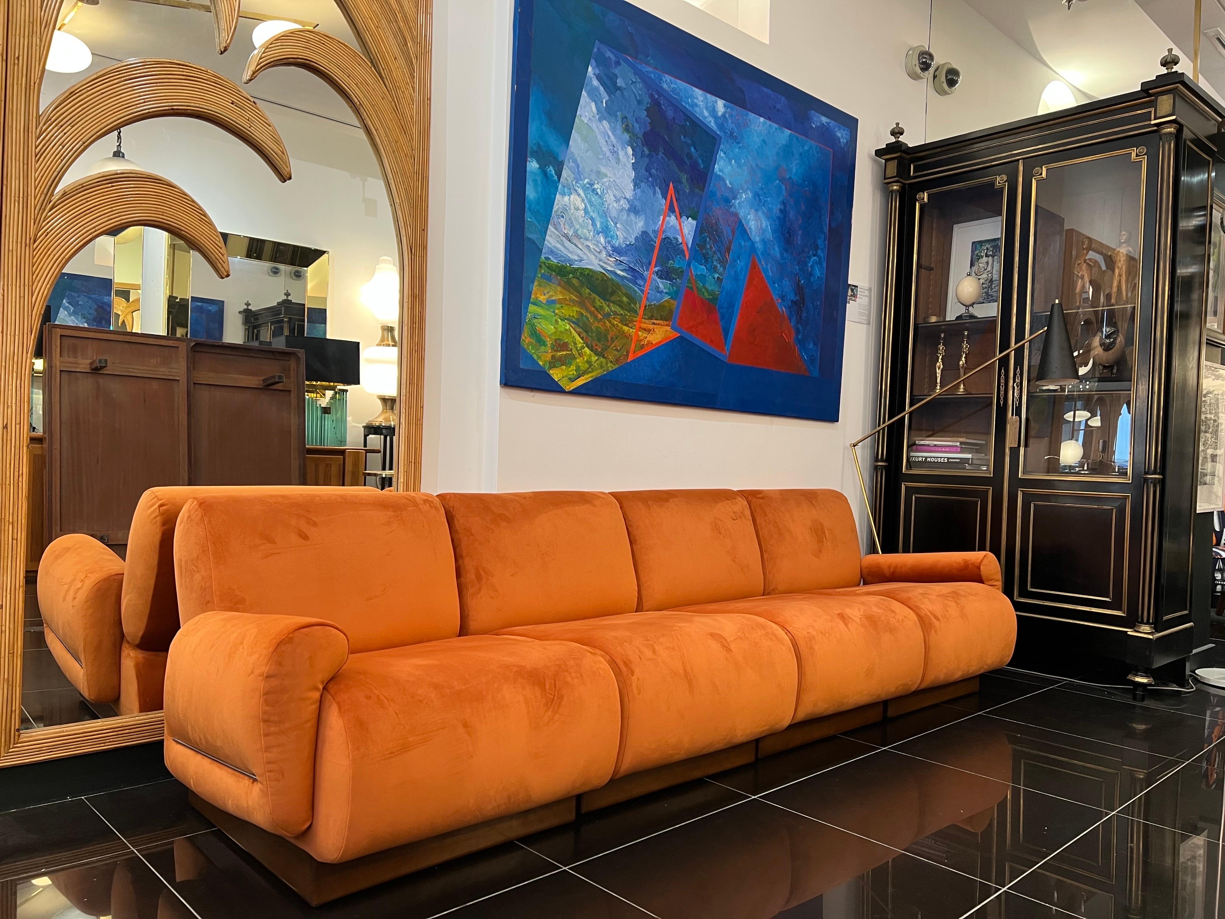 A stunning four section modular sofa C1970 newly upholstered and restrung in lush burnt orange velvet . The sofa sits on a walnut wood frame and consists of 4 seats that can be separated to form a two or three seater with one or two chairs .. the