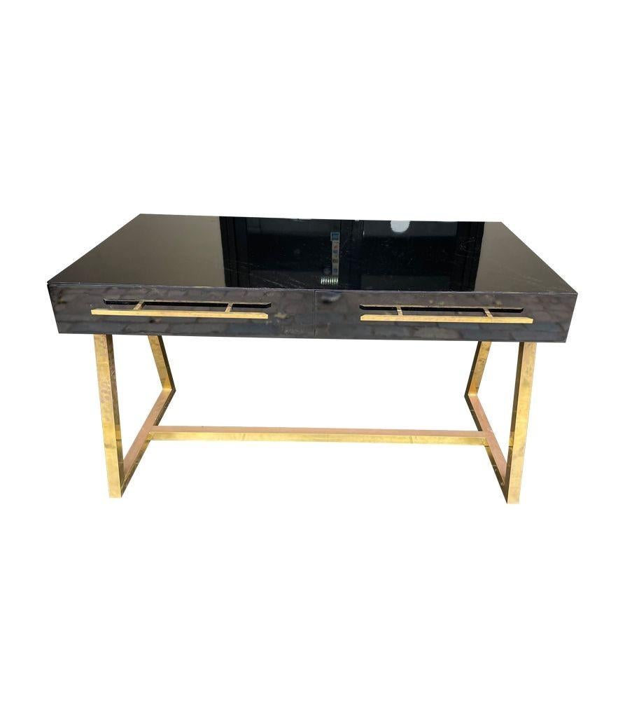An Italian 1980s mid century style black lacquer and brass desk with two drawers with brass handles.
