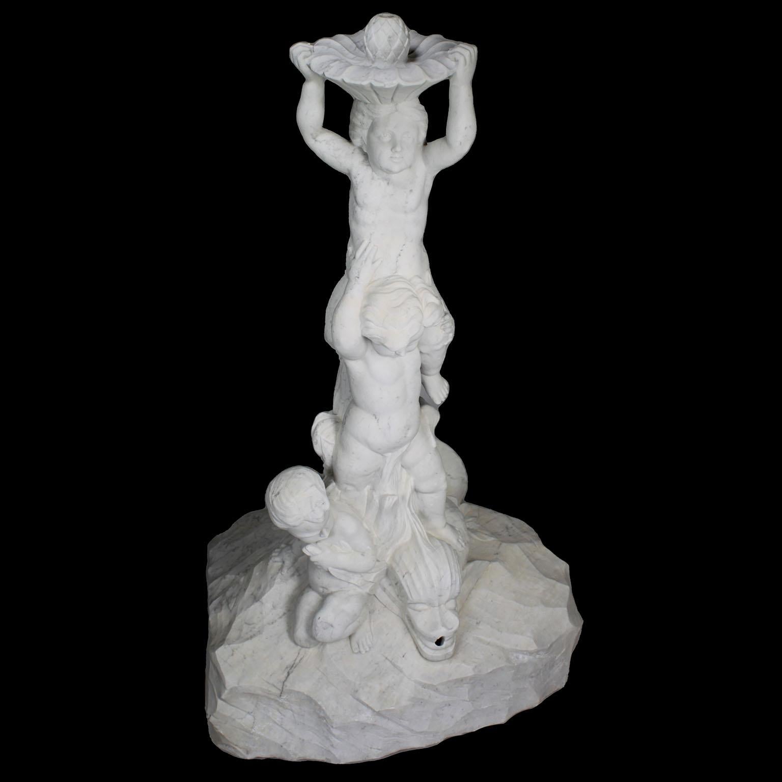 Charmante fontaine figurative italienne du 19e/20e siècle en marbre sculpté représentant trois Putti enjoués chevauchant un poisson Koi. Circa : Florence 1900.

Entrez dans un royaume de charme et d'art avec cette charmante fontaine figurative en