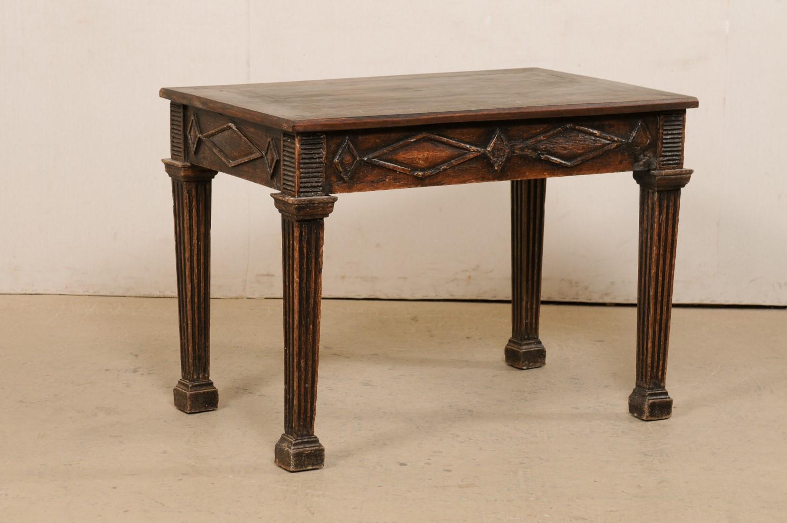An Italian nicely carved occasional table from the 19th century. This antique table from Italy has a rectangular-shaped top with a large, but subtle diamond shape within its center, which rests above a skirt embellished with thick, raised