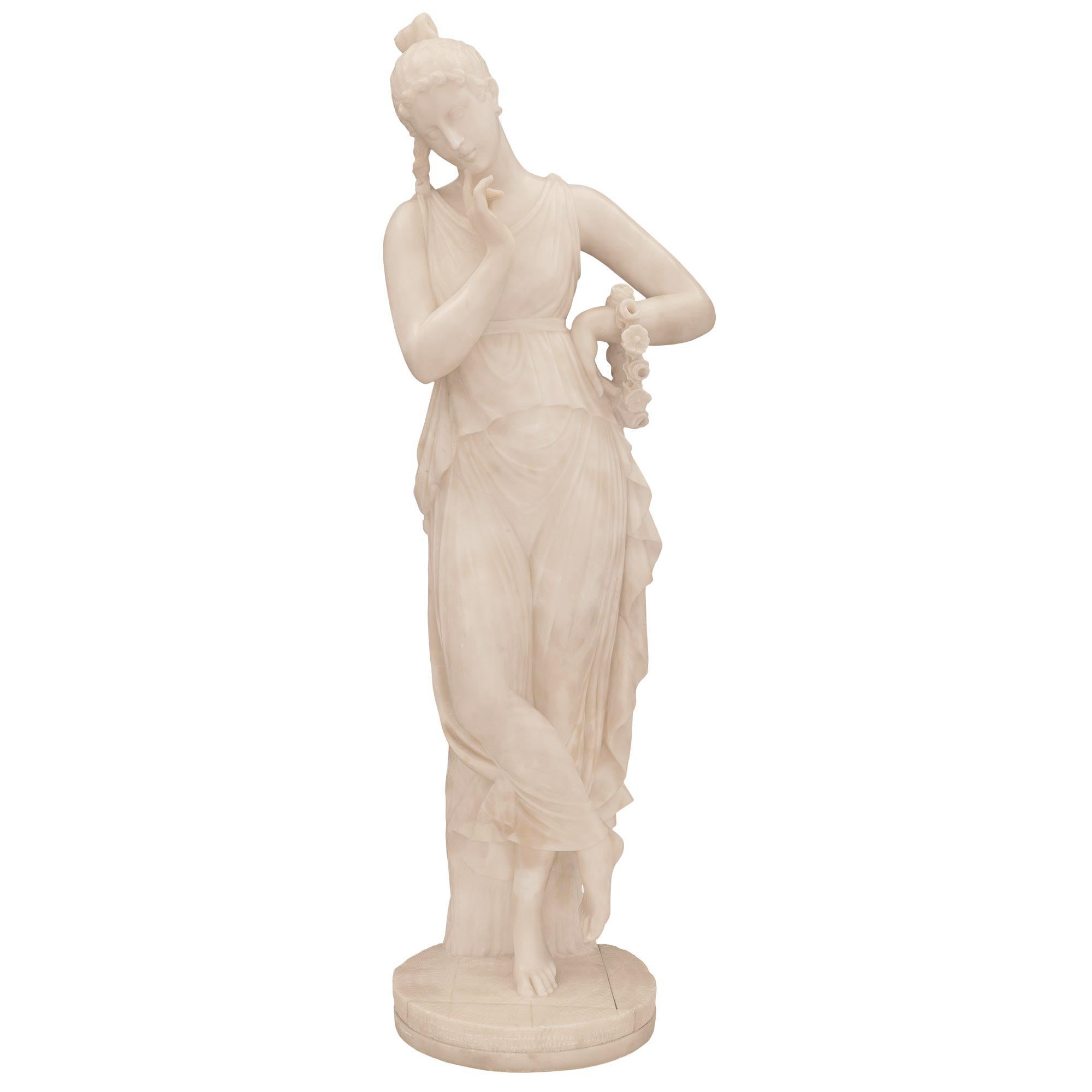 A striking Italian 19th century Alabaster statue of a beautiful maiden after a model by Antonio Canova. The statue is raised by a circular base with a most decorative ground like design where the wonderfully executed maiden is standing in front of a