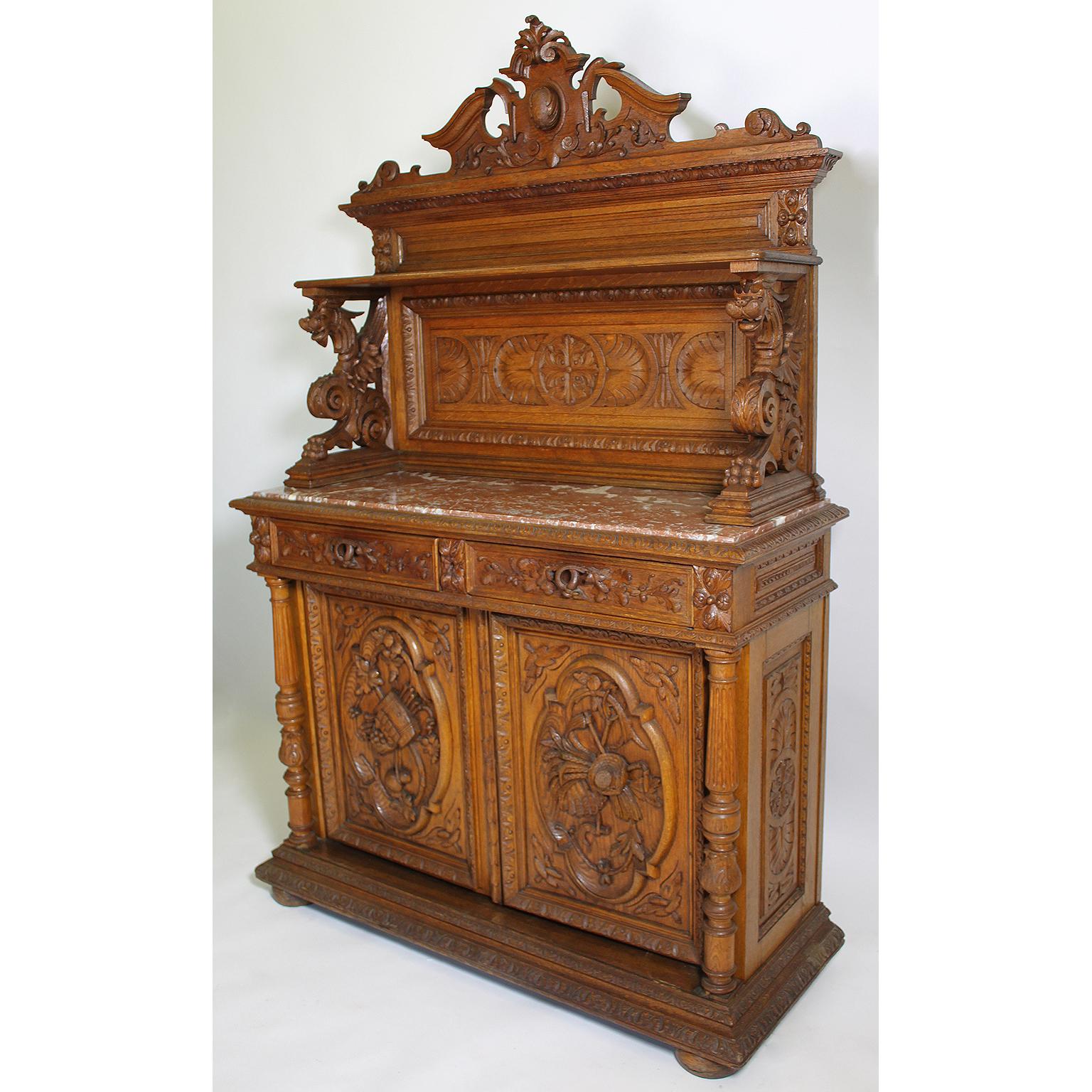 A fine and rare Italian 19th century Baroque Renaissance Revival style oak-carved figural server cabinet. The upper part crowned with an architectural carving above a paneled shelf, surmounted on each side with a figure of winged dragons, all above