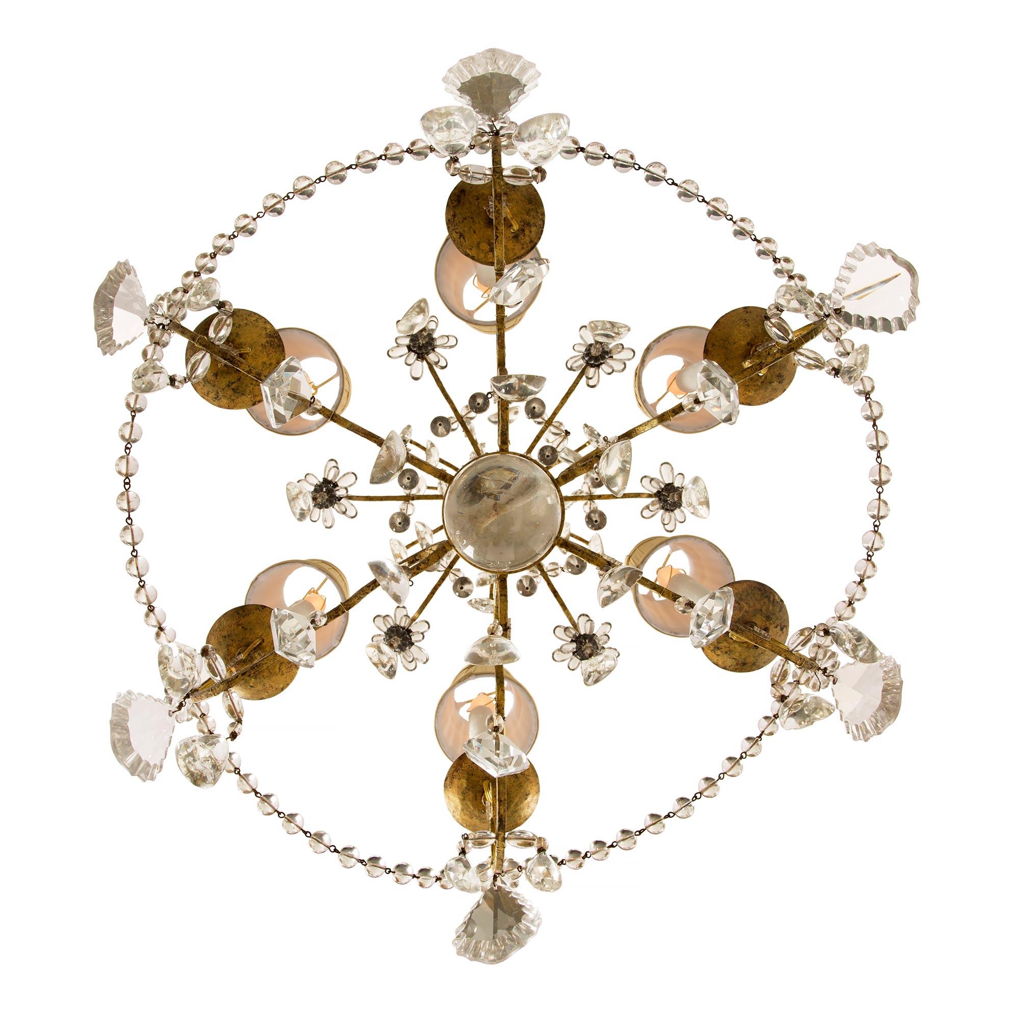 A lovely Italian 19th century Louis XV style gilt iron crystal and glass six arm chandelier. The chandelier is centered by a Fine solid bottom crystal ball amidst lovely cut crystal pendants. Each elegantly scrolled arm is decorated with large