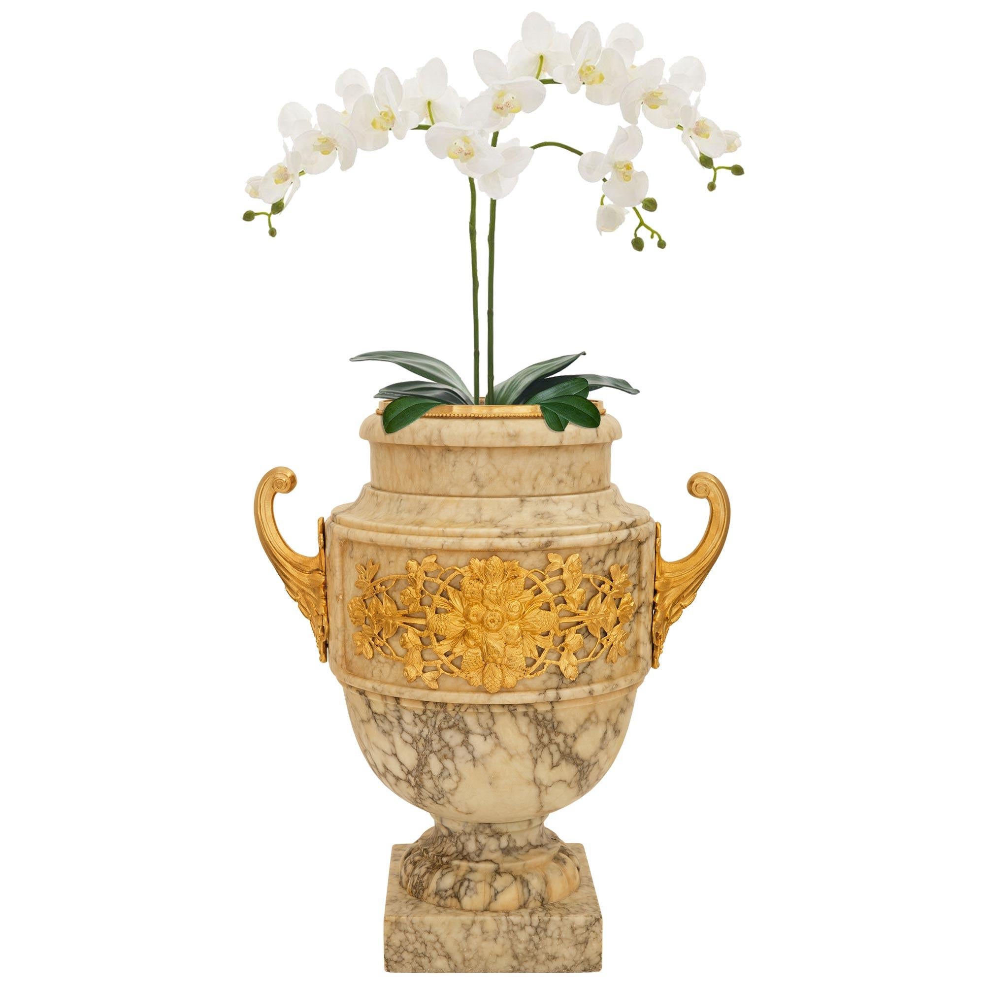 Preciosa e impresionante maceta/jarrón de alabastro y ormolu del siglo XIX italiano, estilo Luis XVI. Esta maravillosa jardinera se eleva sobre un zócalo cuadrado de alabastro bajo el zócalo circular estriado. El cuerpo superior muestra paneles
