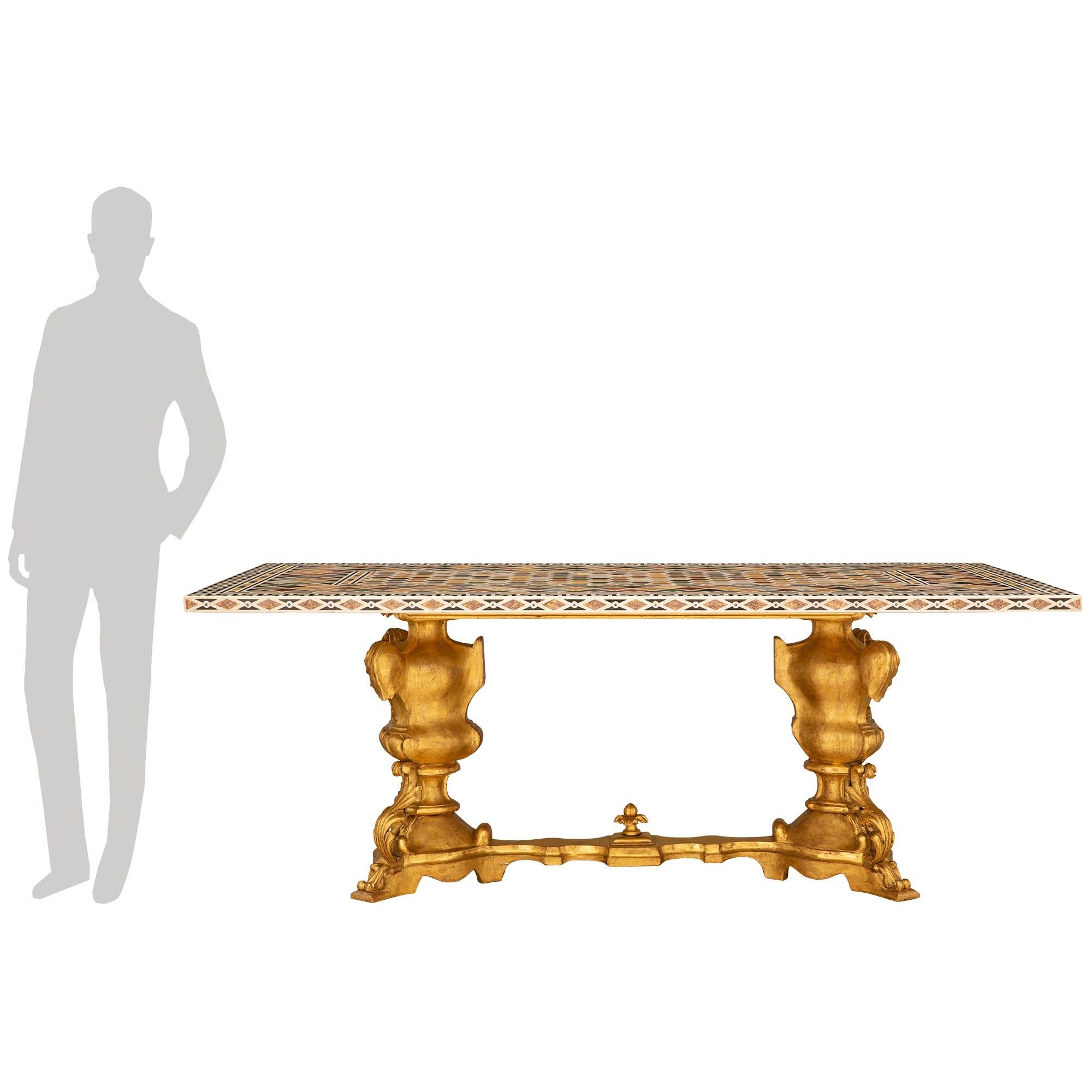 
A sensational and extremely decorative Italian 19th century Specimen marble and Giltwood center/dining table. The table is raised on a Baroque st. giltwood base with two baluster shaped supports decorating with scrolled acanthus leaves and gadroon