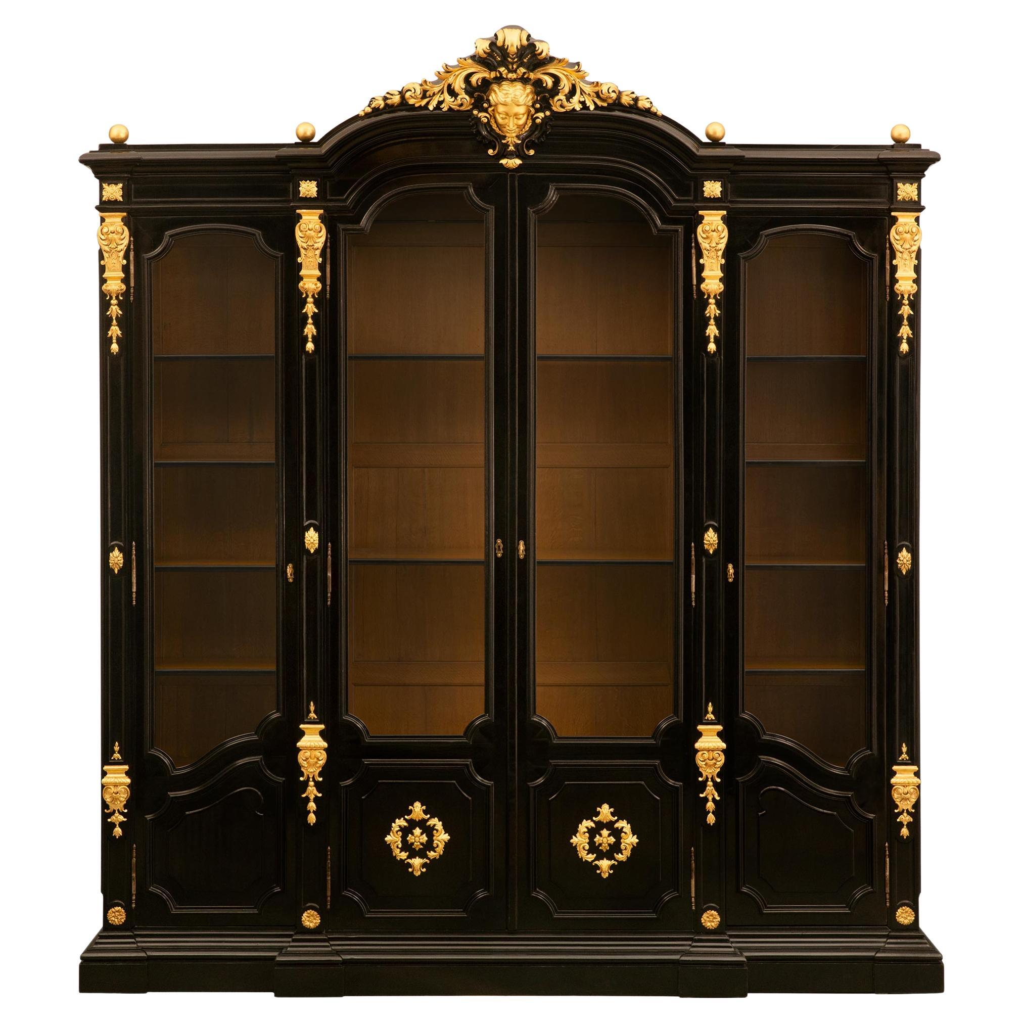 An Italian 19th century Rococo Revival st. ebonized giltwood vitrine For Sale