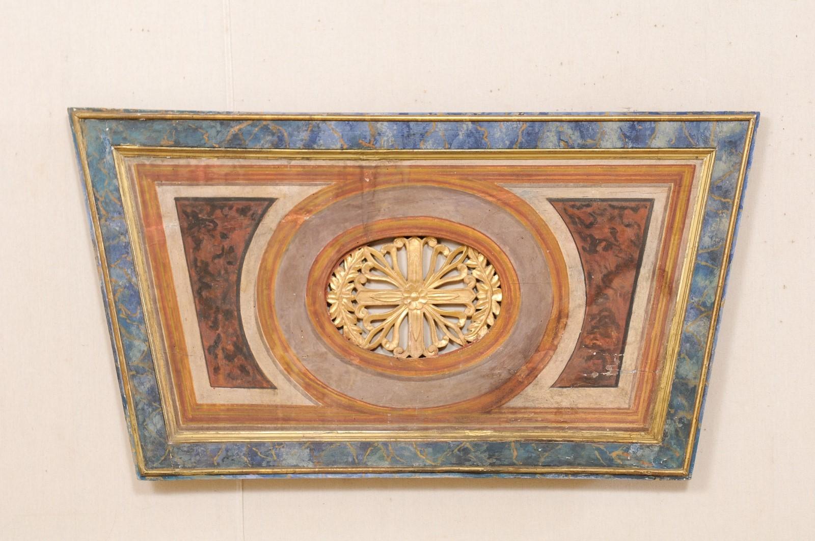 An Italian decorative wall plaque with trapezoid shape from the 19th century. This antique wall ornament from Italy has an inverted trapezoid shape, with oval center comprised of a pierced carved floral medallion flanked within a pair of leaves. The