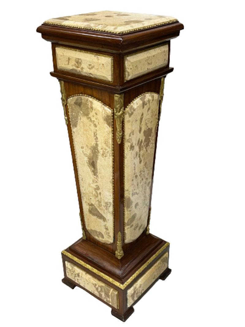 An Italian 20th century pedestal

An Italian 20th century pedestal of mahogany wood with yellow marble panels surrounded by brass ornaments. 
The height of the pedestal is 99 cm. 
The bottom foot is 32.5 cm square and the top is 30 cm square.