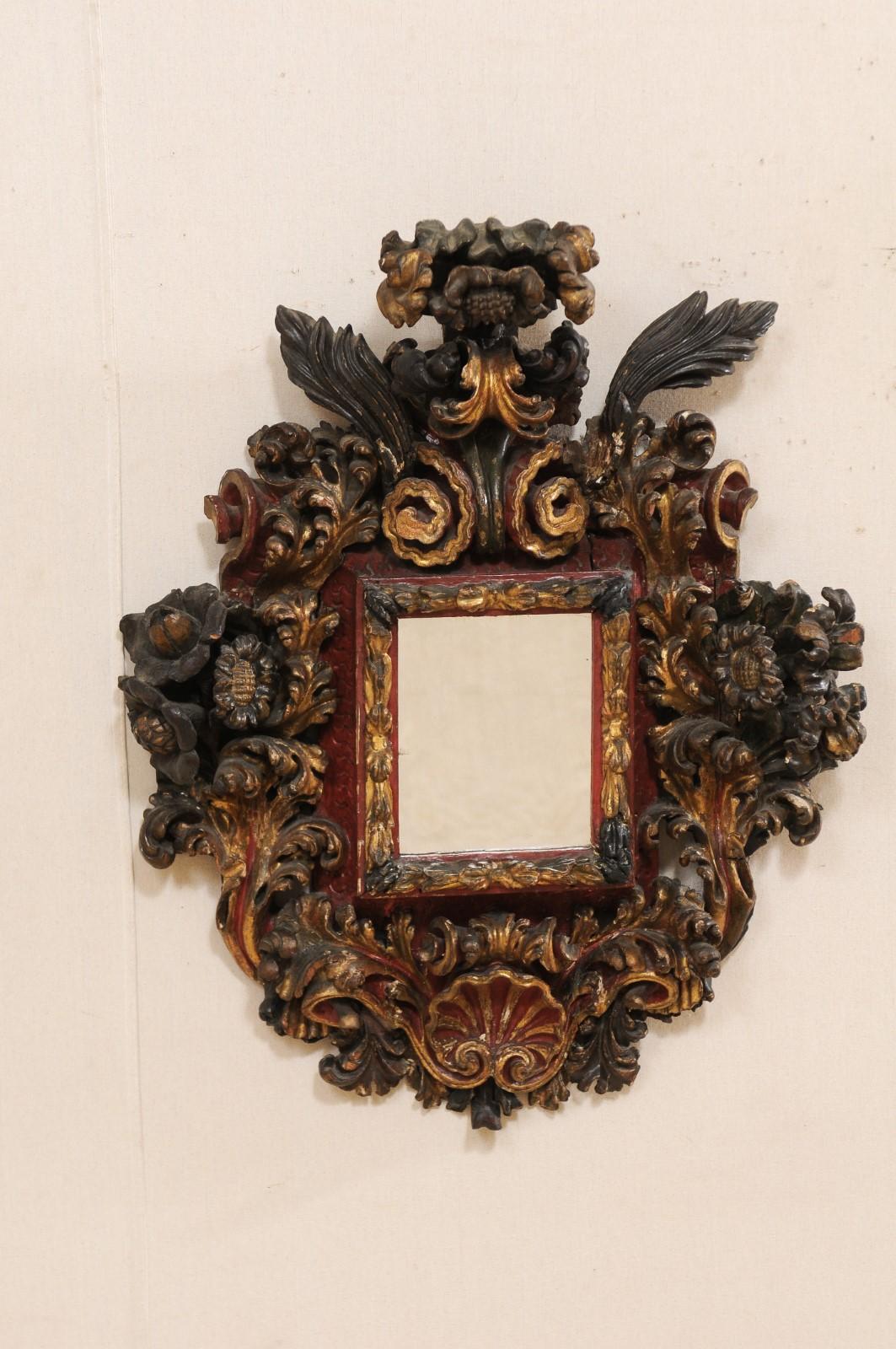 An impressive Italian baroque carved wood wall plaque with center mirror from the 18th century. This antique wall decoration from Italy features ornate three dimensional hand carvings in a shell, floral, and scrolling acanthus leaf motif, about a