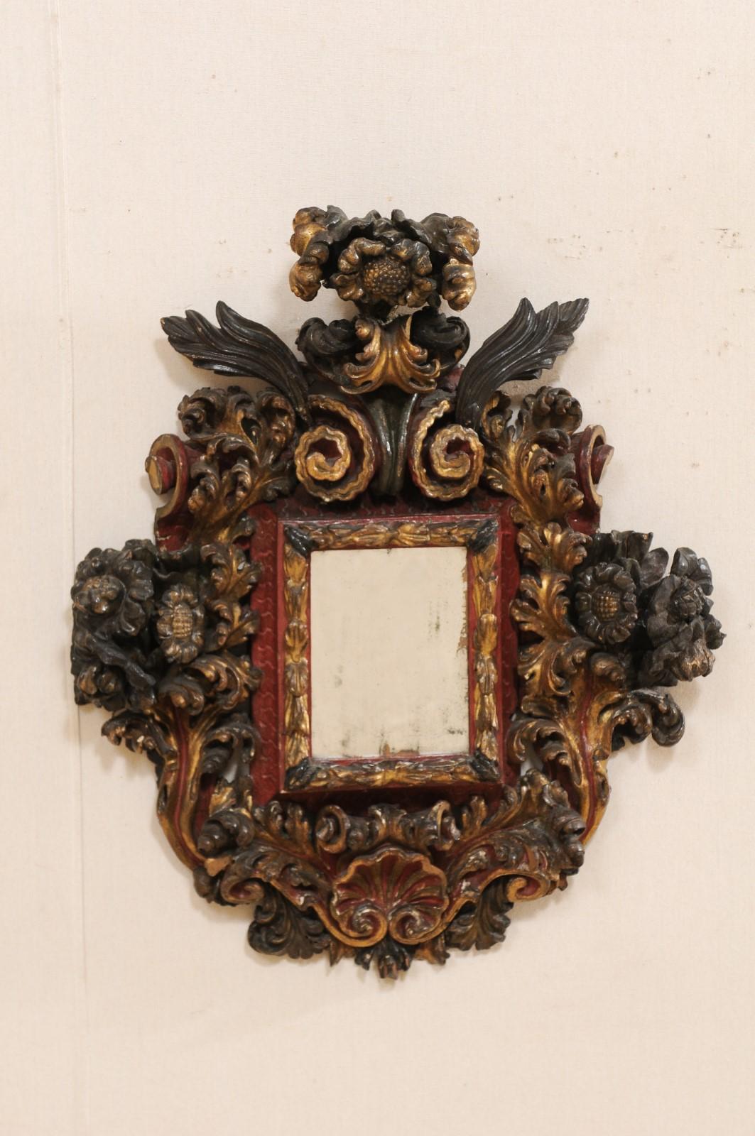 An impressive Italian Baroque carved wood wall plaque with center mirror from the 18th century. This antique wall decoration from Italy features ornate three dimensional hand carvings in a shell, floral, and scrolling acanthus leaf motif, about a