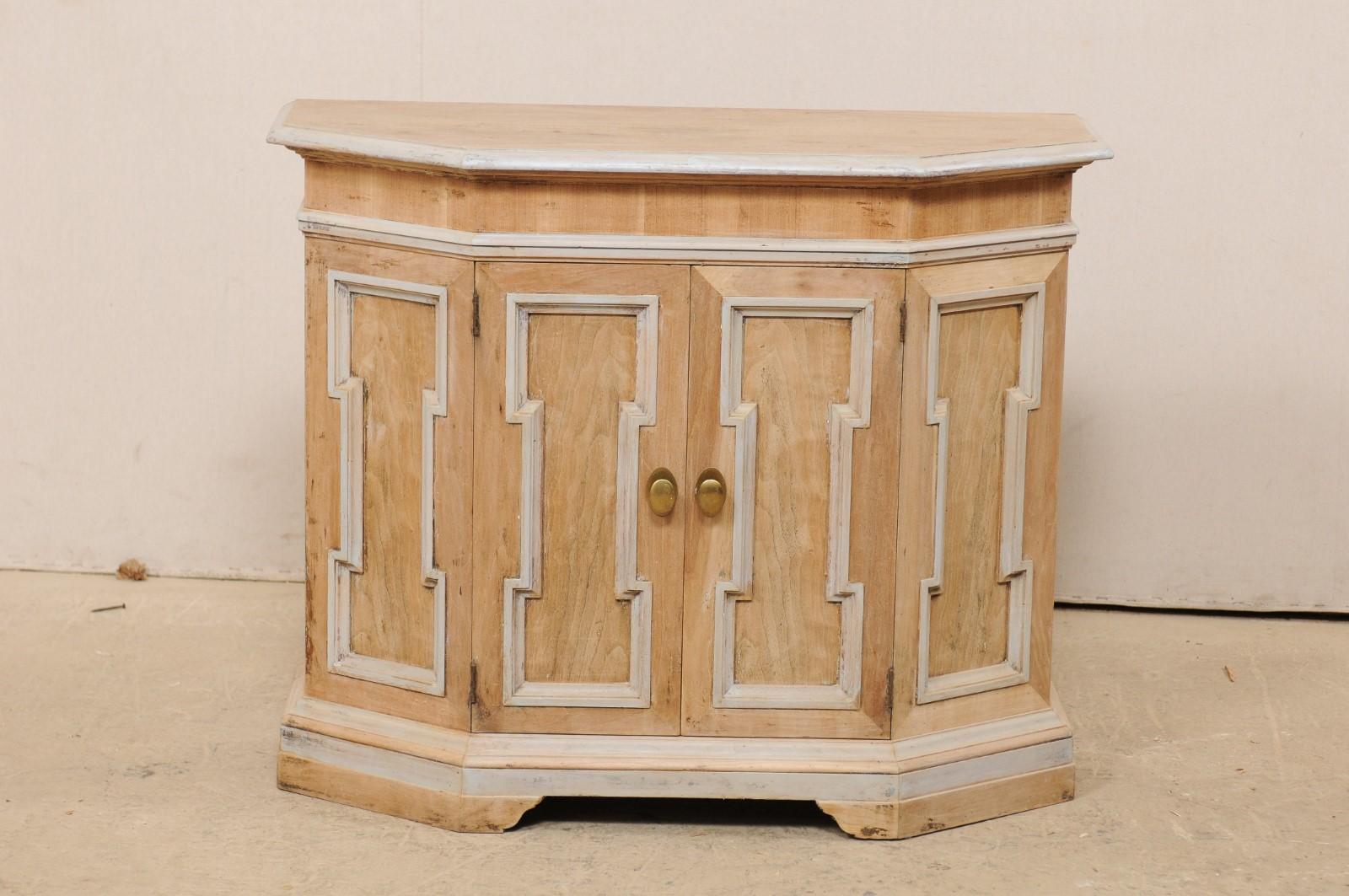 An Italian petite-sized console cabinet from the mid-20th century. This vintage cabinet from Italy features a top with flat sided front giving way to two chamfered sides, with the cabinet beneath mimicking the shape of the canted top. The case