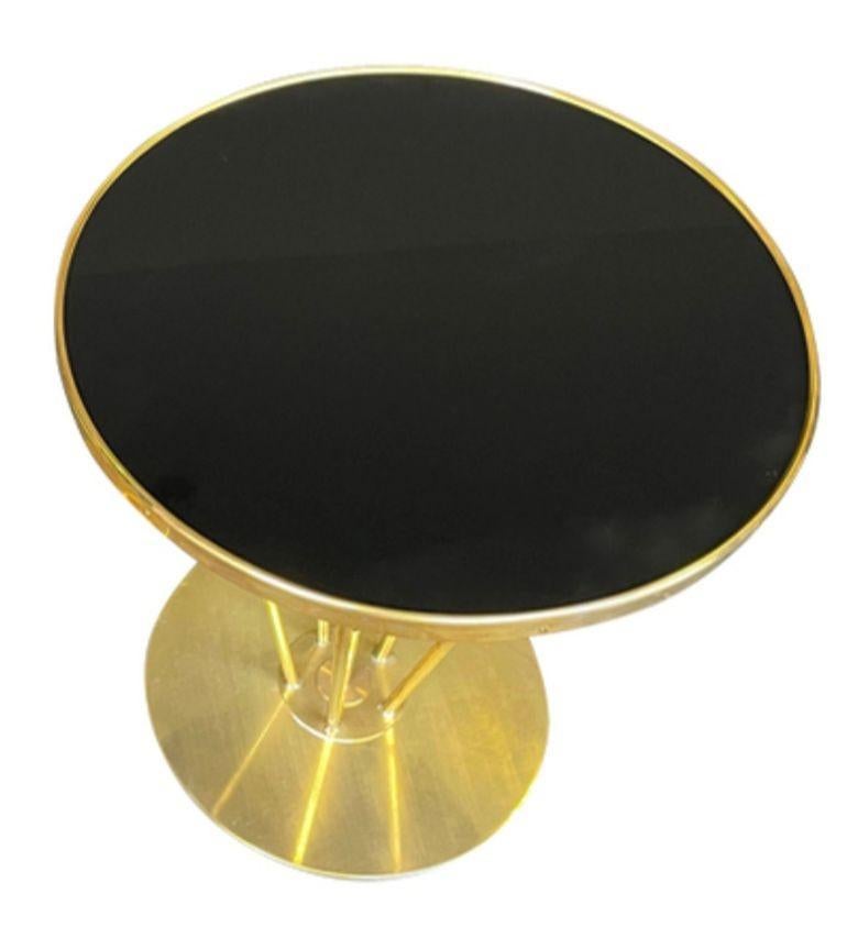 Mid-Century Modern An Italian brass and black glass circular side table en vente