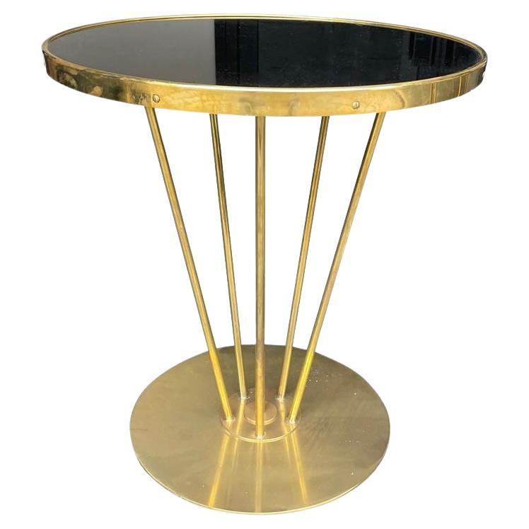 An Italian brass and black glass circular side table