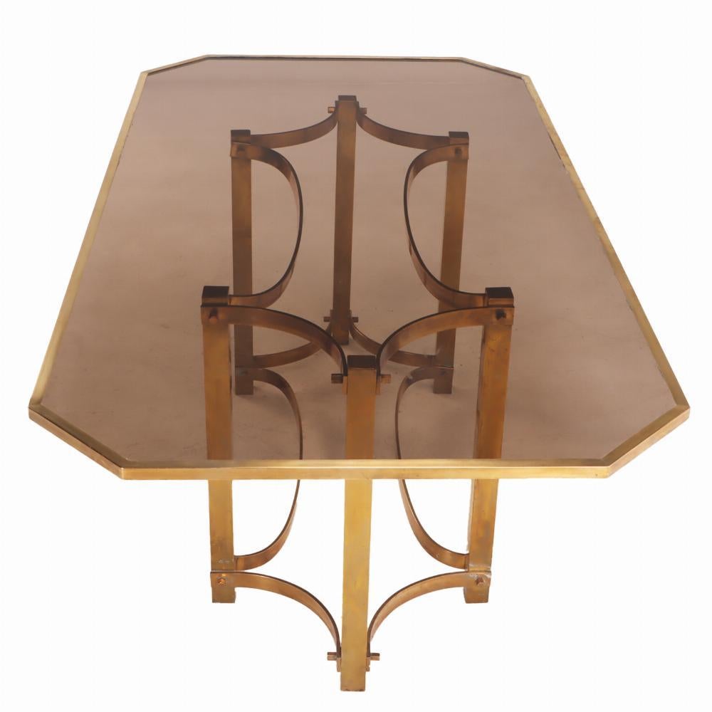 The cut corner, rectangular glass top supported by six legs joined by a pinched race track stretcher.

Could be a great addition as a dining table or perhaps a desk.