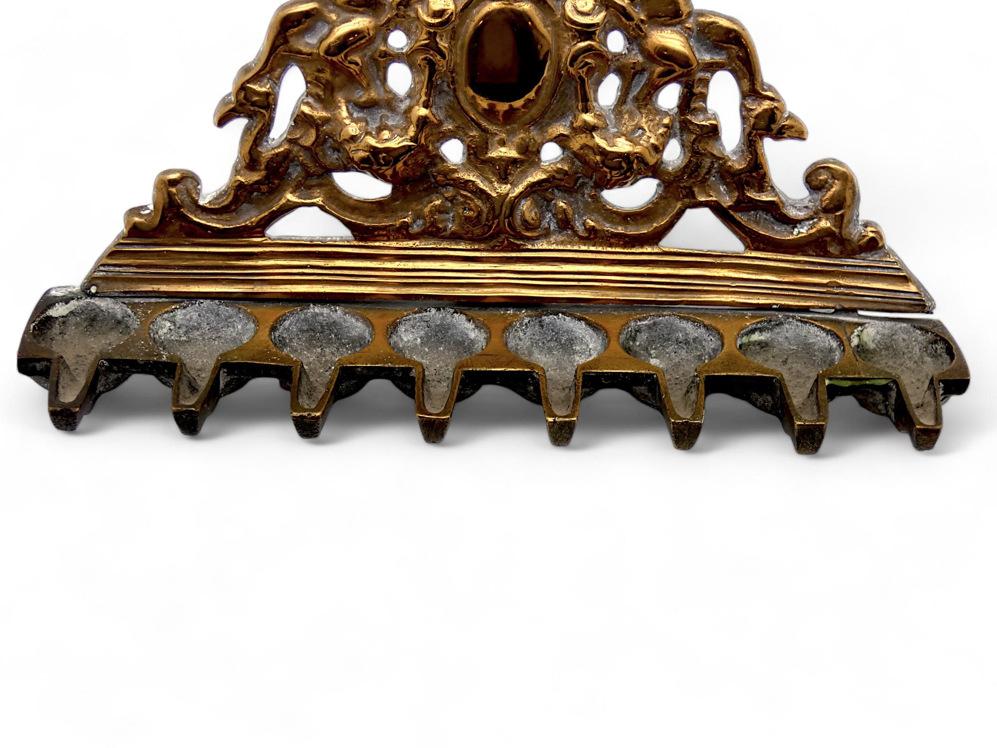 Una lampada di Hanukkah dal design meraviglioso realizzata in Italia nel 17-18° secolo, forse prima.

Questa piastra per la lampada di Hanukkah ha una forma triangolare, come era classico nei vecchi design italiani di mobili, cornici in legno e