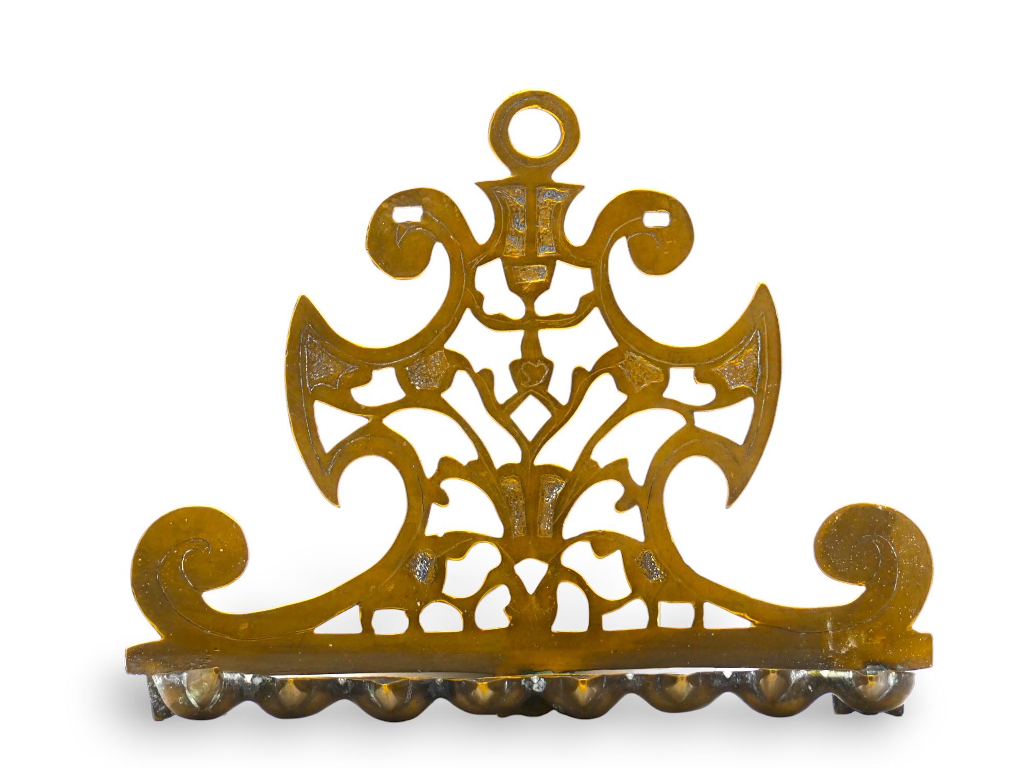 Un'insolita lampada Hanukkah italiana in ottone del XVIII secolo.

L'insolita forma angolare delle lampade di Hanukkah si basa su quella delle lampade precedenti, con una solida piastra posteriore e una Menorah a sette bracci al centro.

Questa