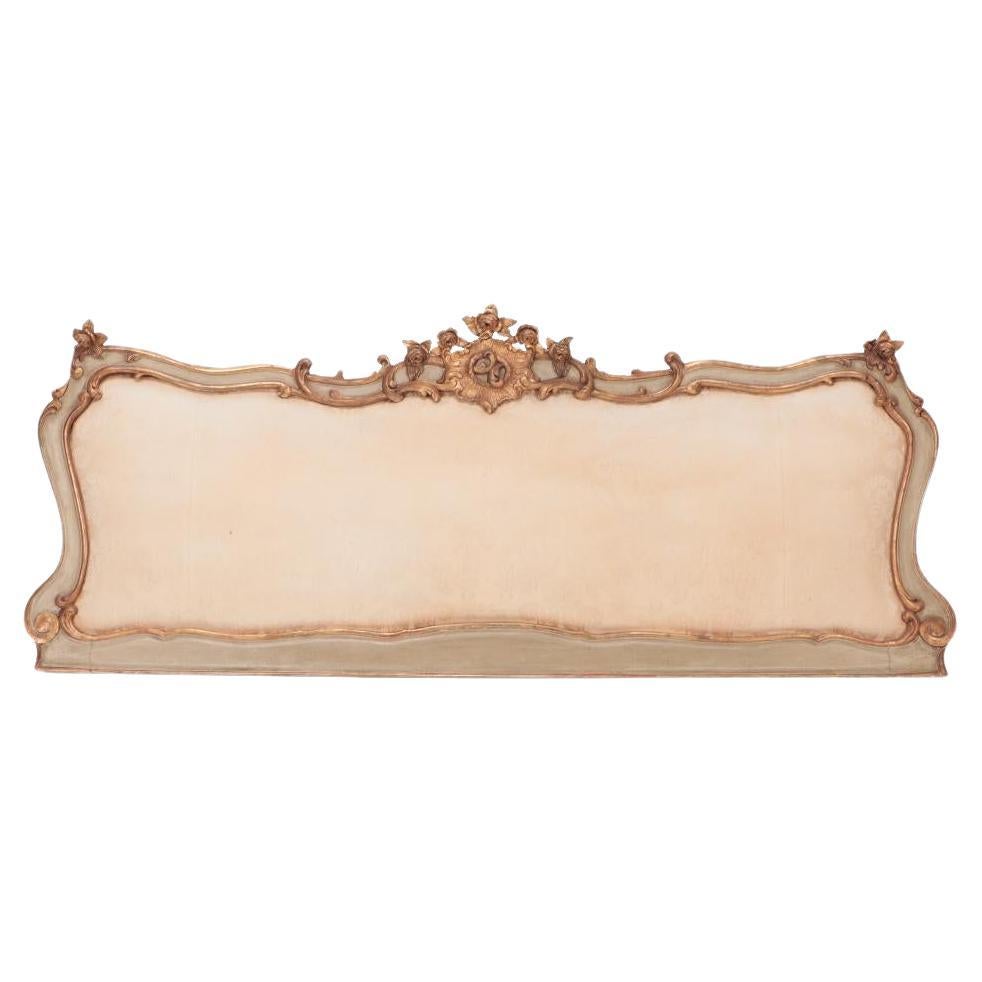 An Italian carved and painted giltwood King size headboard circa 1900.