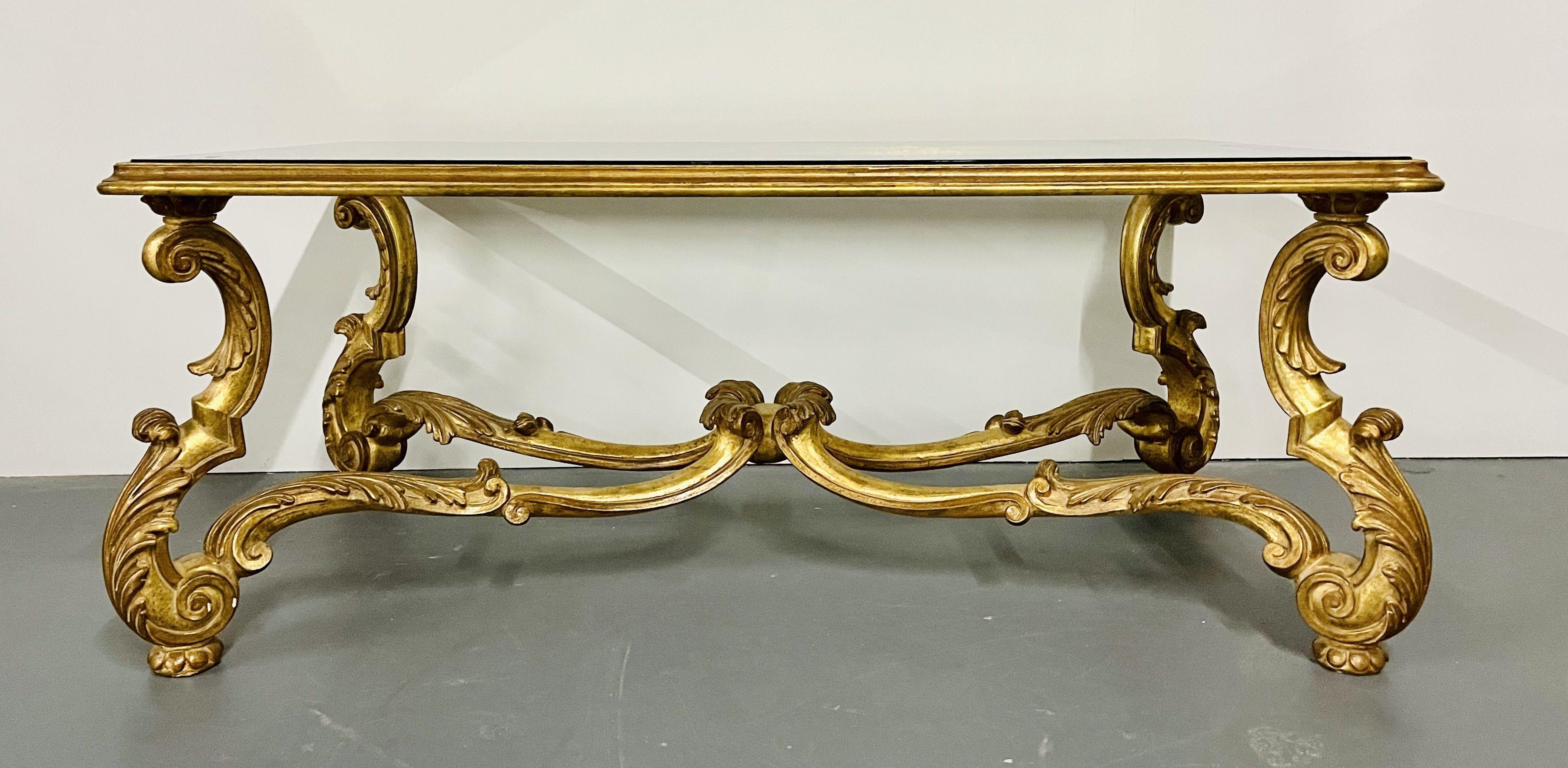 An Italian carved glass top coffee, cocktail table, gilt wood, Hollywood Regency, Mid-Century Modern. This fine custom made table is 22 kt gilt over wood with wonderful Rococo carvings having a glass top that sits inside the frame of the