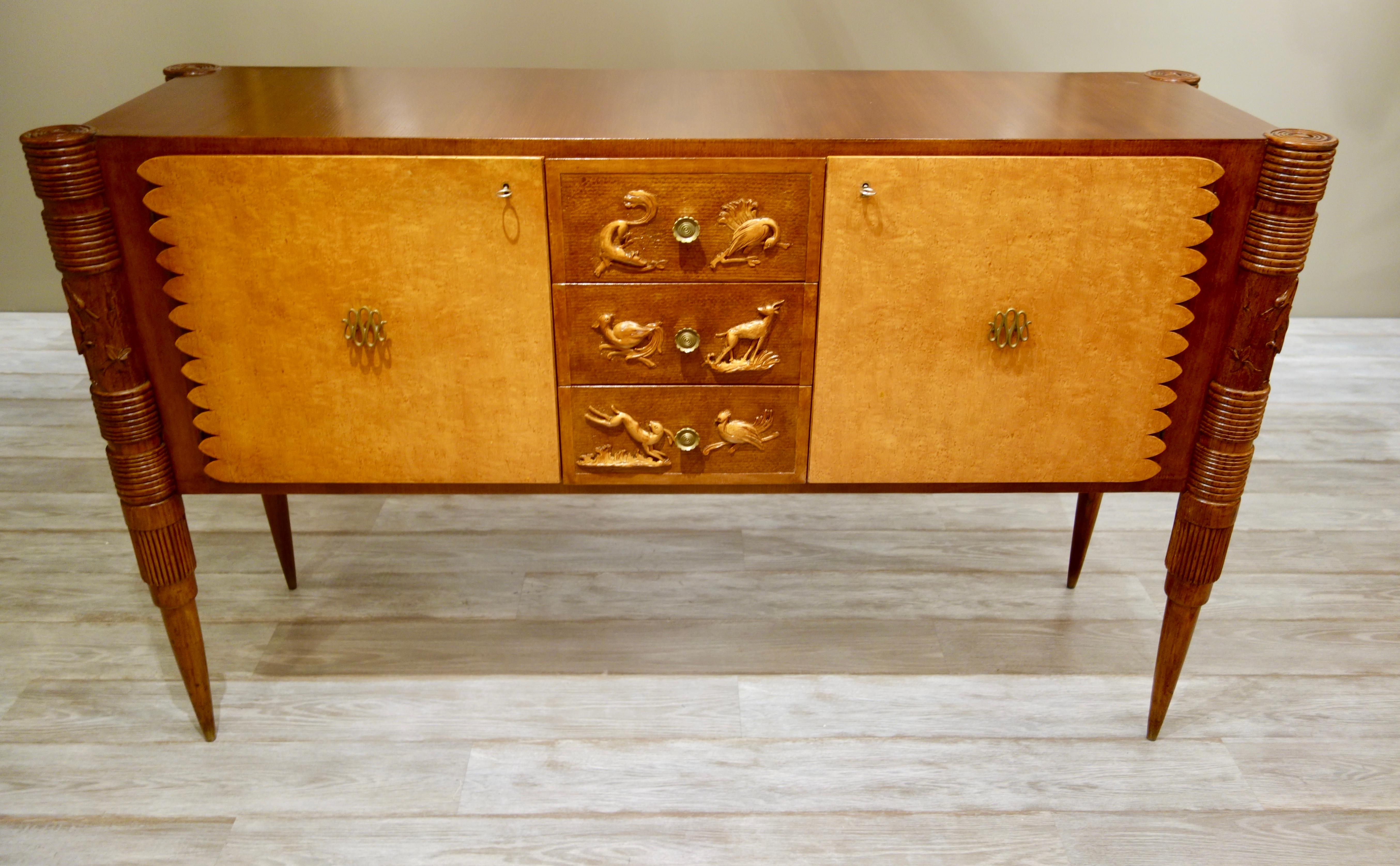 An Italian carved wood sideboard or credenza by Pier Luigi Colli for the renowned manufacturer, Marelli in Cantu, in contrasting darker ash and lighter veneered burled maple with two larger scalloped doors with original brass pulls flanked by three