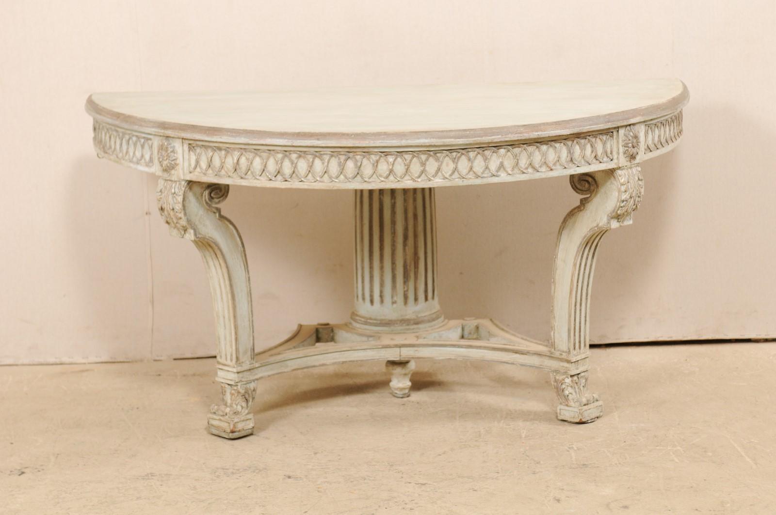 An Italian half-round console table with nicely carved details from the mid-20th century. This vintage demilune table from Italy features a halved-moon shaped top, with thick apron beneath which has been carved in an overlaying circular motif,