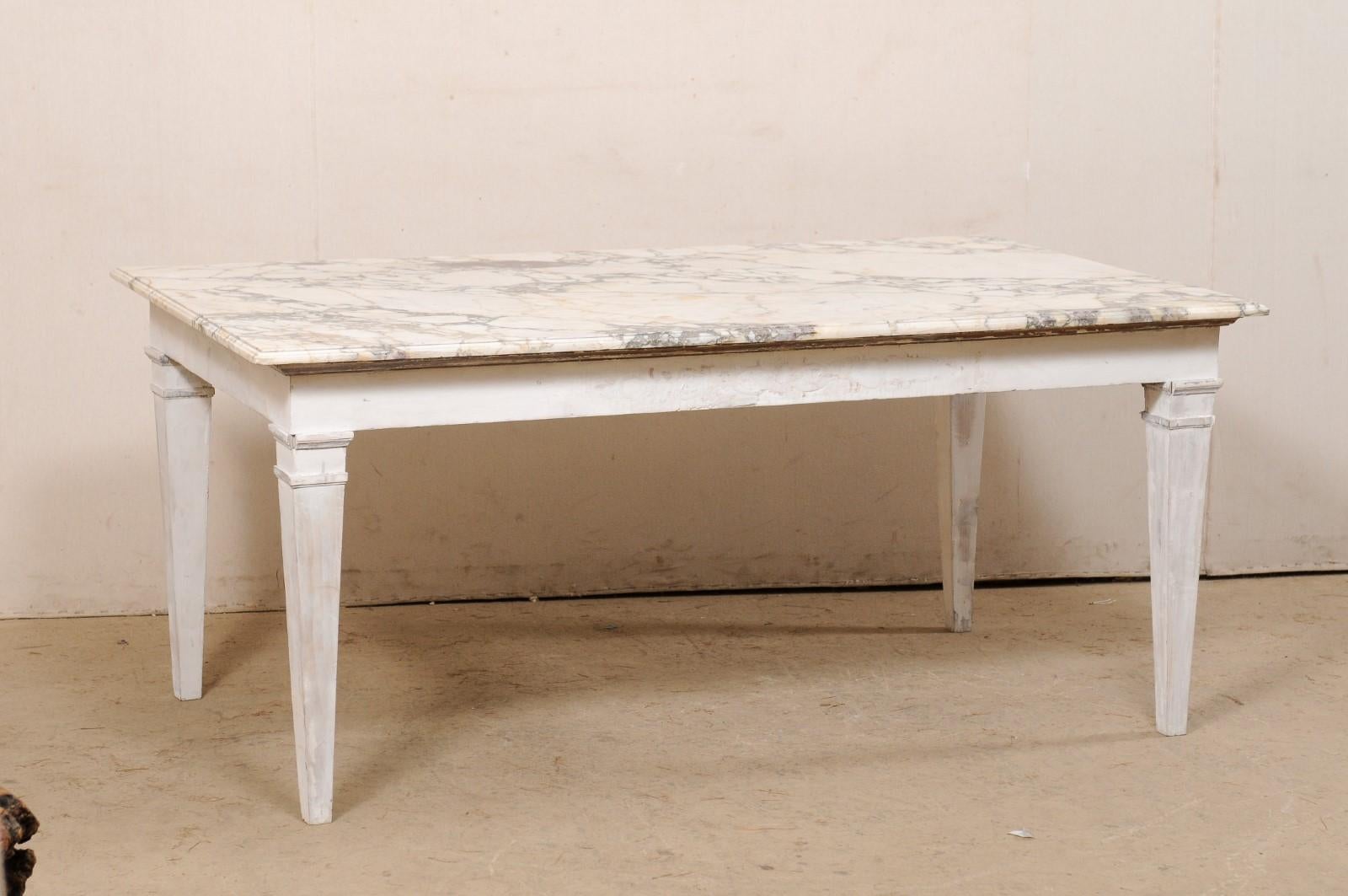An Italian painted wood table with original marble top. This vintage table from Italy is topped with its original rectangular-shaped marble top, which gives this piece a length of just over 5.5 feet, and has a nice creamy white color with gray,