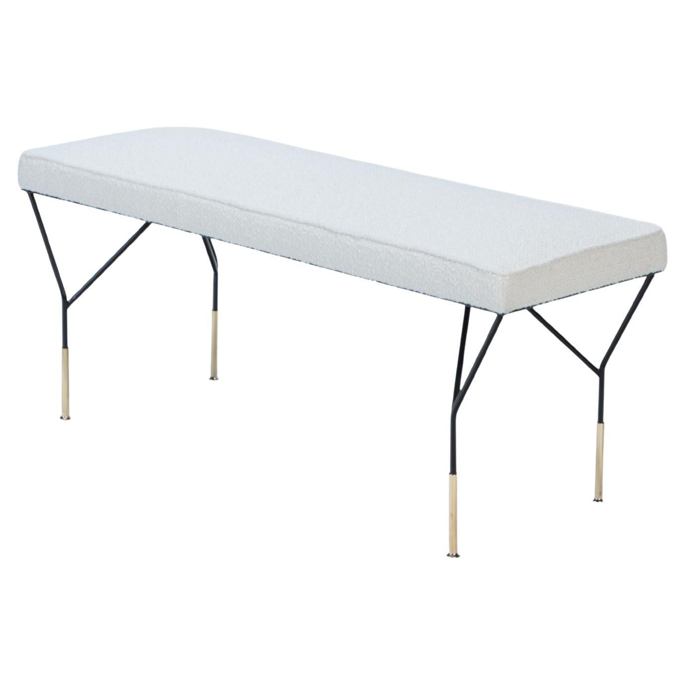 An Italian contemporary metal and brass bench with white upholstered seat.