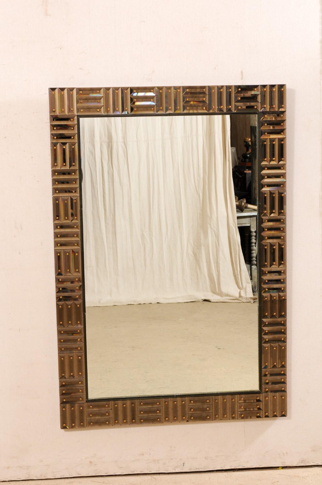 An Italian-made Duca mirror from luxury home furnishings maker/designer Donghia. This Venetian glass mirror from Italy is rectangular-shaped with a thickly bordered surround in smoky amber glass pieces (rectangular shaped pieces in sets of three