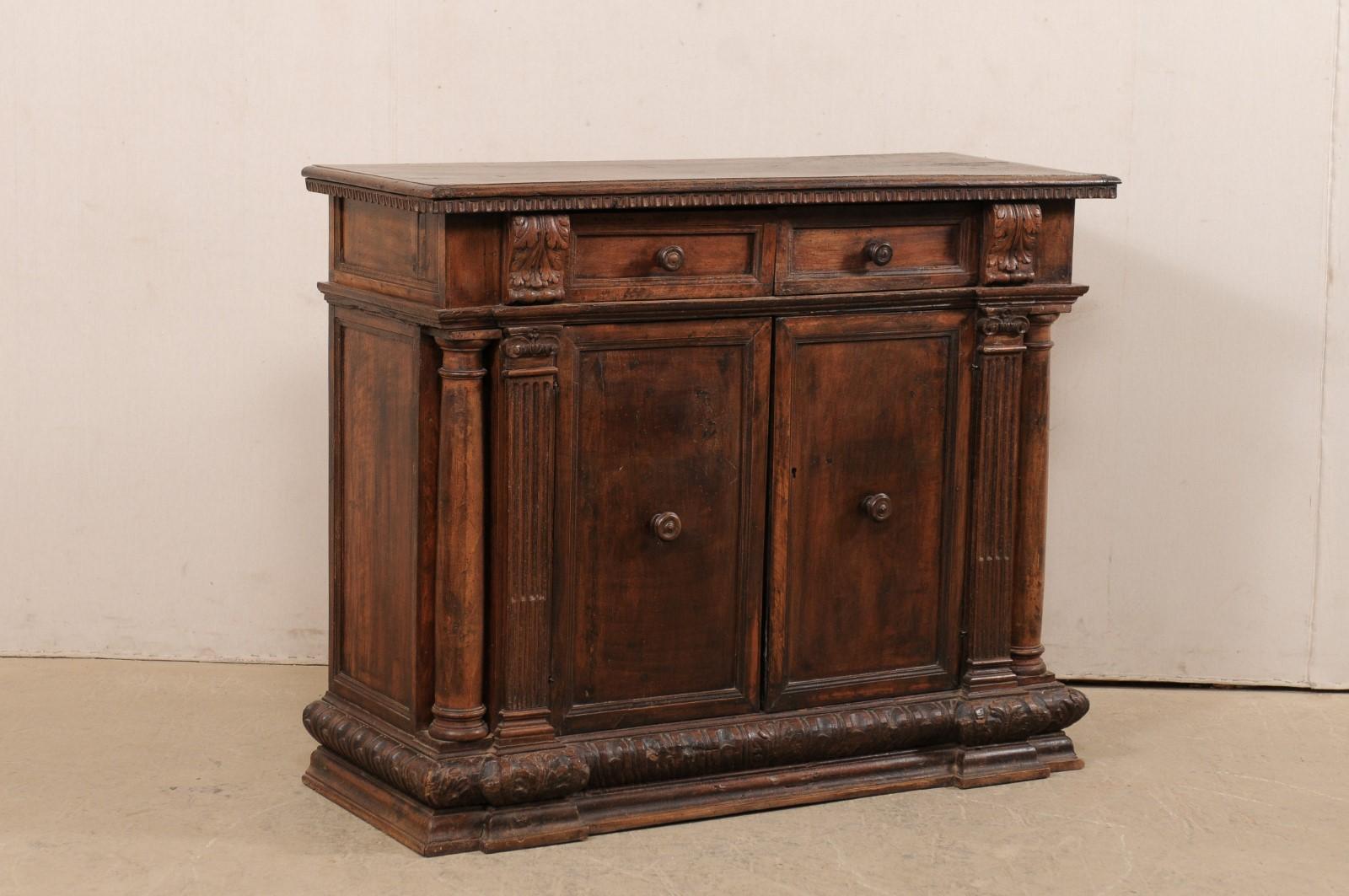 An Italian beautifully-carved walnut cabinet from the early 19th century, possibly older. This antique walnut buffet from Italy features a rectangular-shaped top with a carved egg-n-dart trim under it's perimeter edges. Raised acanthus leaf carvings