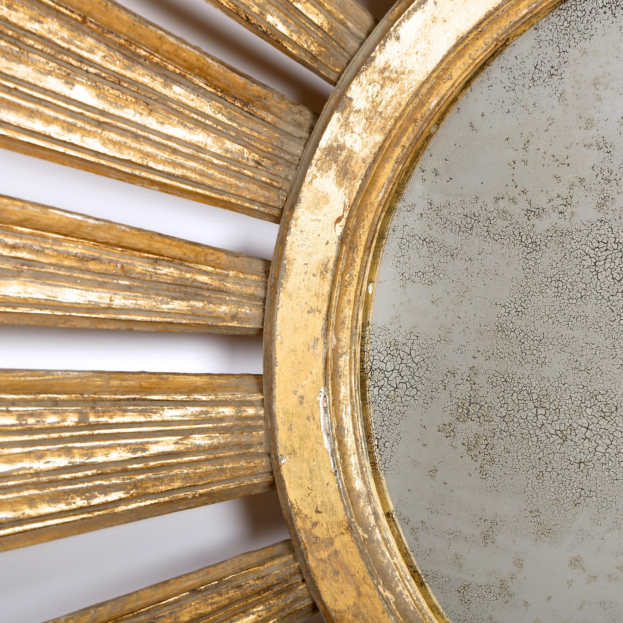 An early 20th century sunburst mirror of very large scale, with giltwood rays emanating from the circular mercury mirror plate to the centre.