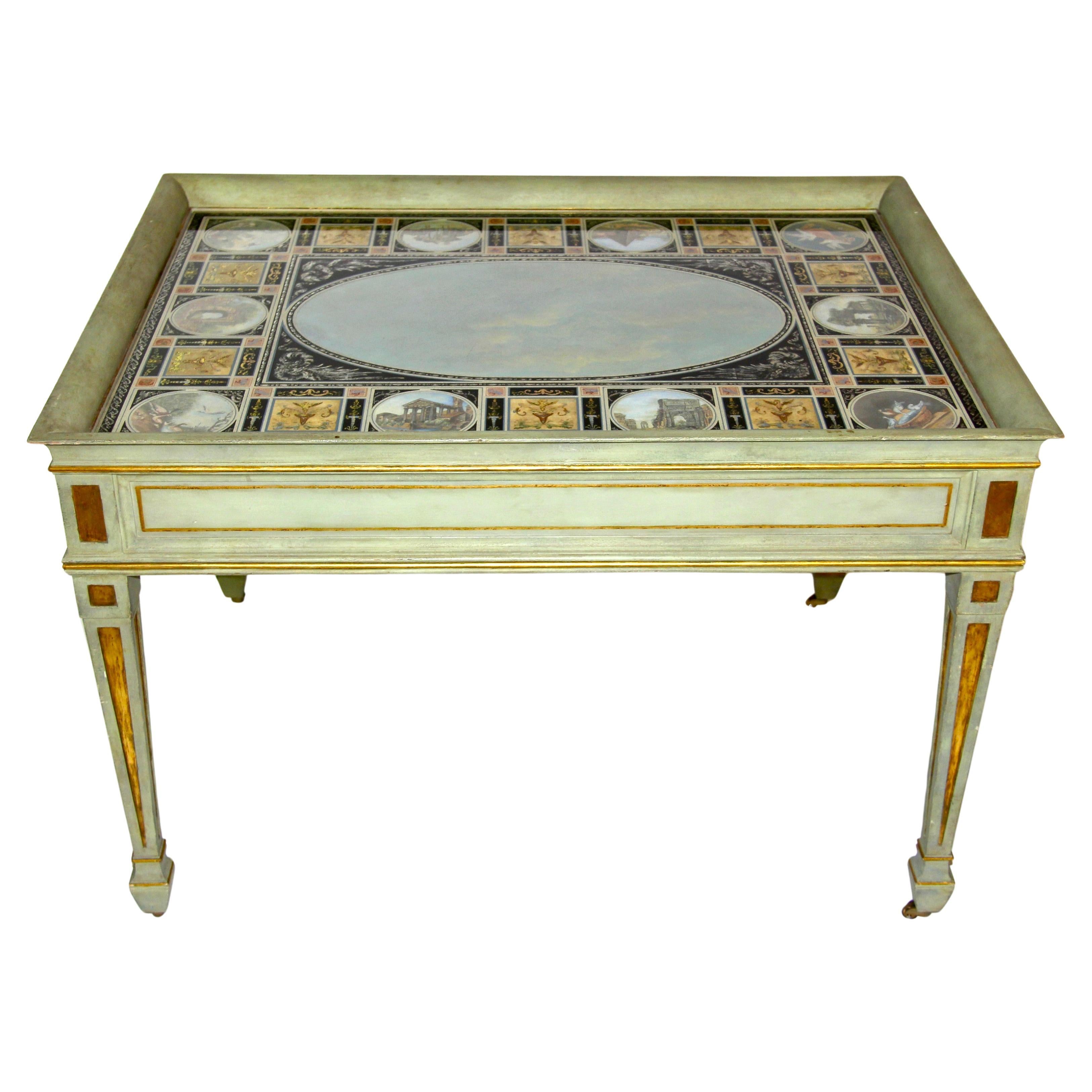 Table basse italienne à plateau en églomisé, peinte et dorée.  Table basse rectangulaire en bois peint présentant un entourage de galerie en relief et un panneau supérieur en verre peint en églomisé. La partie supérieure est centrée par une grande