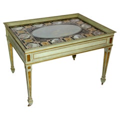 Ein italienischer Couchtisch aus Eglomise mit bemalter Glasplatte und lackierter/vergoldeter Holzplatte