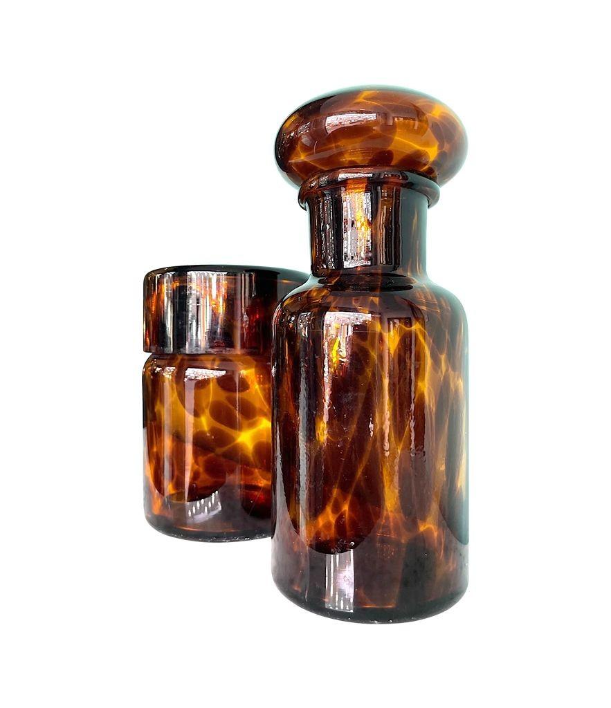 An Italian faux tortoiseshell Murano glass bathroom set by Barovier et Toso. The largest is 22cm x 9cm diameter, the other is 16cm high x 11cm diameter