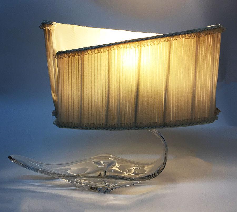 An Italian glass Murano table lamp

An Italian glass Murano table lamp in an organic and barge shape with a lampshade in plisse beige fabric. The lampshade is in original condition and has a very special shape, but will have to be reupholstered,