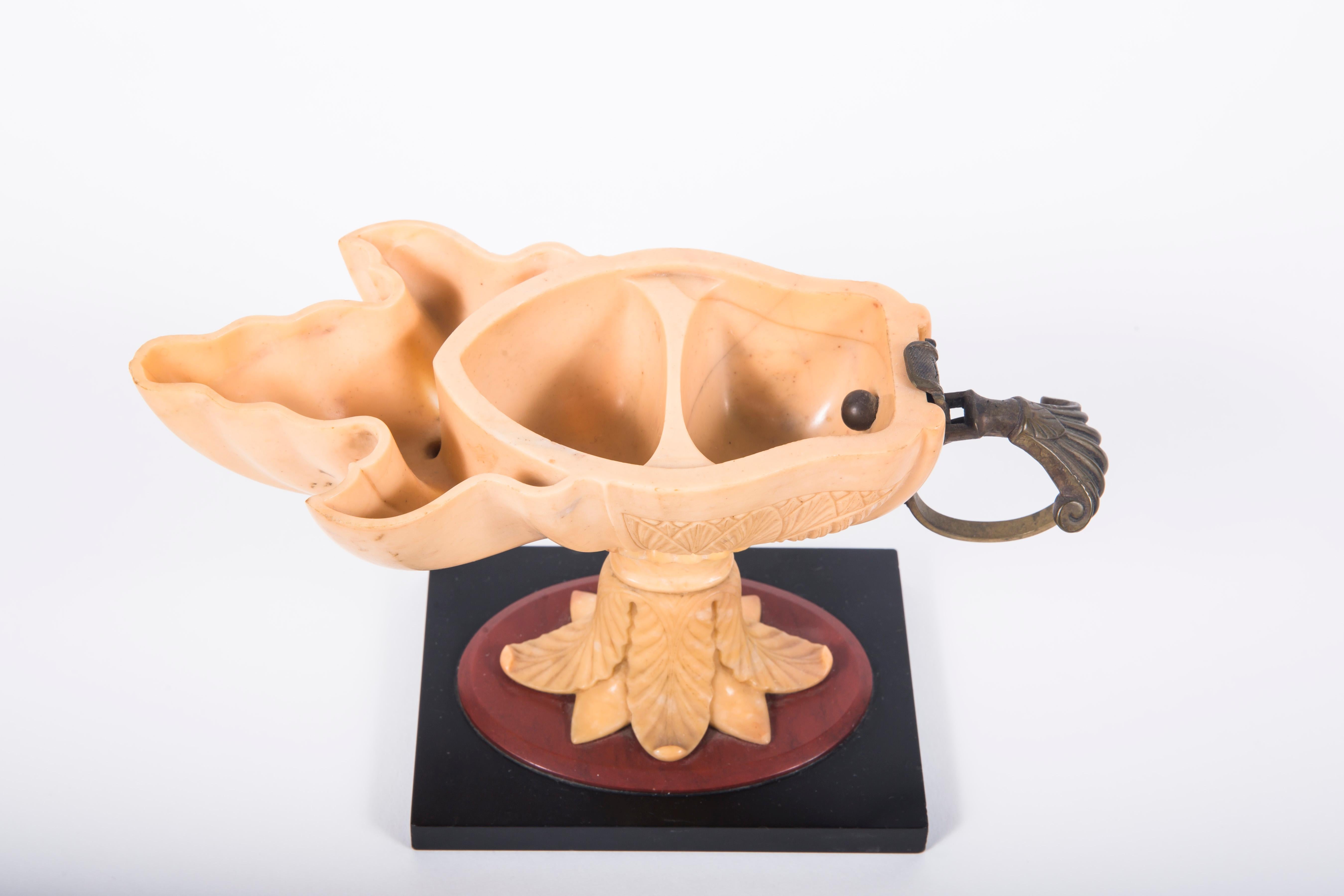 An Italian carved Grand Tour Giallo di Siena oil lamp. Beautifully carved with leaf detailing and rounded bronze handle, set above marble base with rosso antico and nero di belgio. 
Attrb.  Benedetto Boschetti, Rome.
Italian, mid-19th century.

NMA