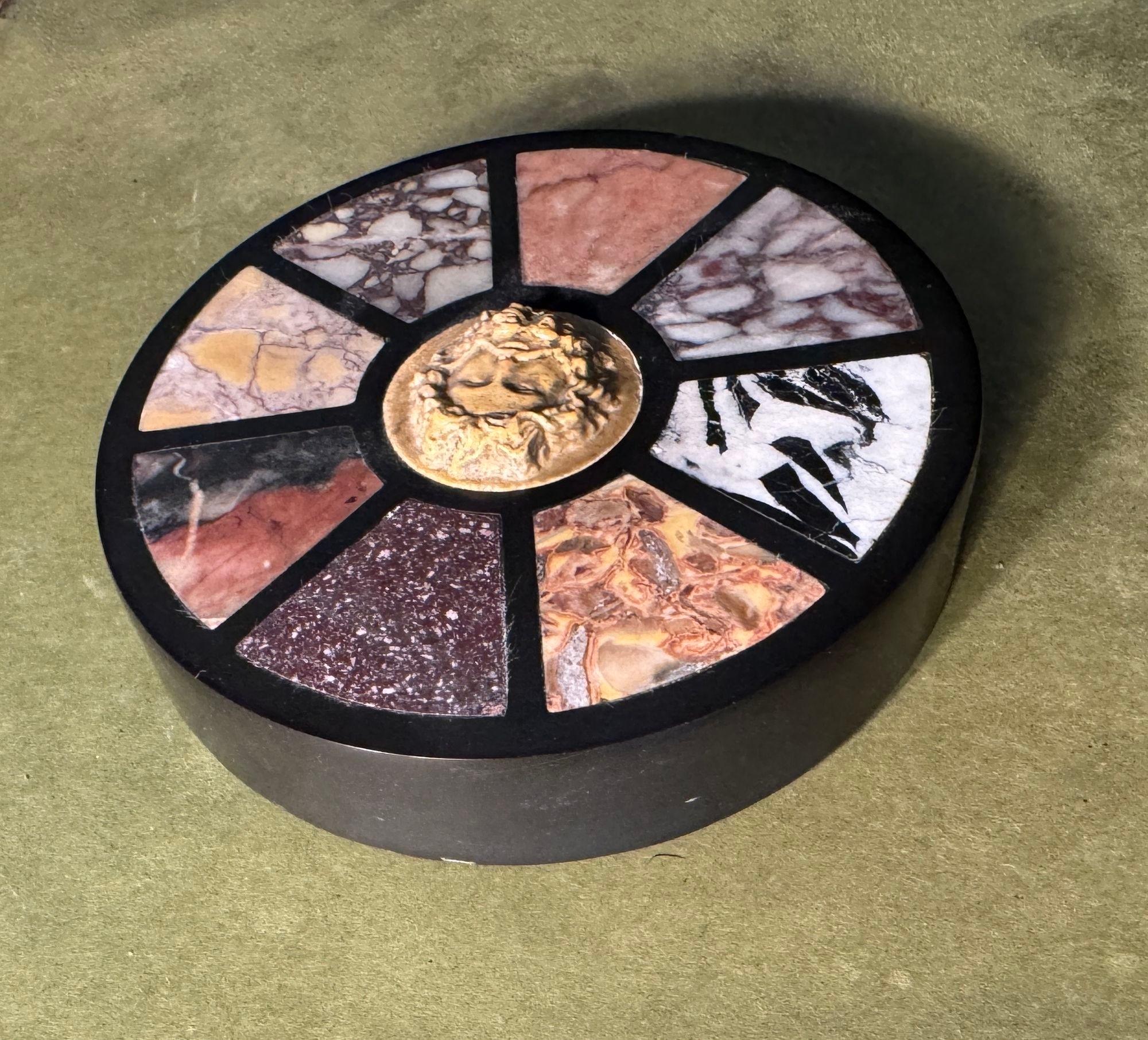 The round paperweight framed in black marble, with porphyry and sienna marble and other marble specimens. The center in sienna marble with carved bearded male head