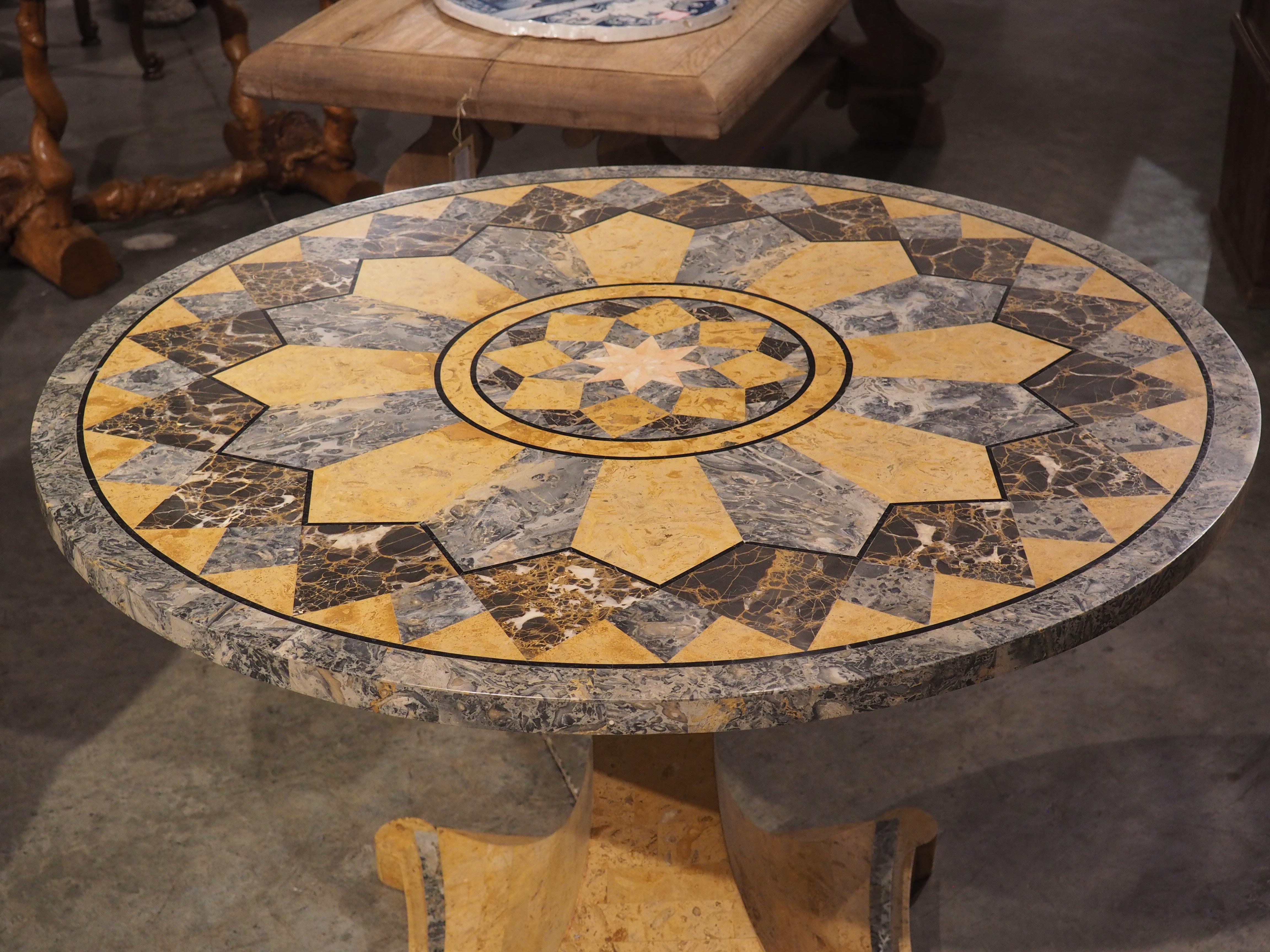 This 20th century center table from Italy features an impressive and beautiful matrix of inlaid marble specimen. Inlay is a decorative technique where colorful materials are placed into carved depressions on a base object. In this case, the base