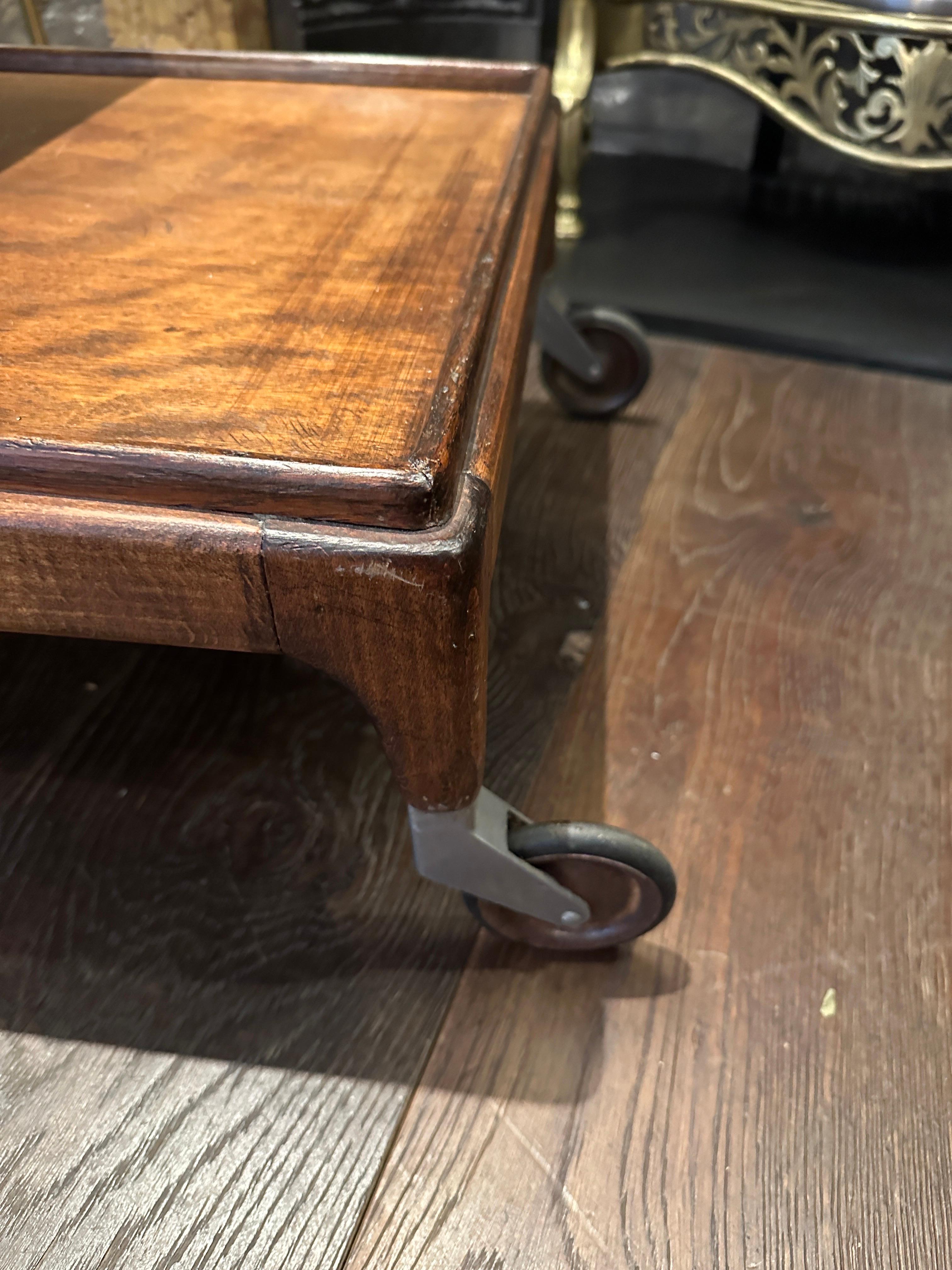 A large 3 tiered walnut bar cart by Cesare Lacca Italy. The top two tiers being removable trays, steel and rubber castors, moustache shaped handle and solid bottom shelf. Shelfs descending in size. Images and video are a true reflection of