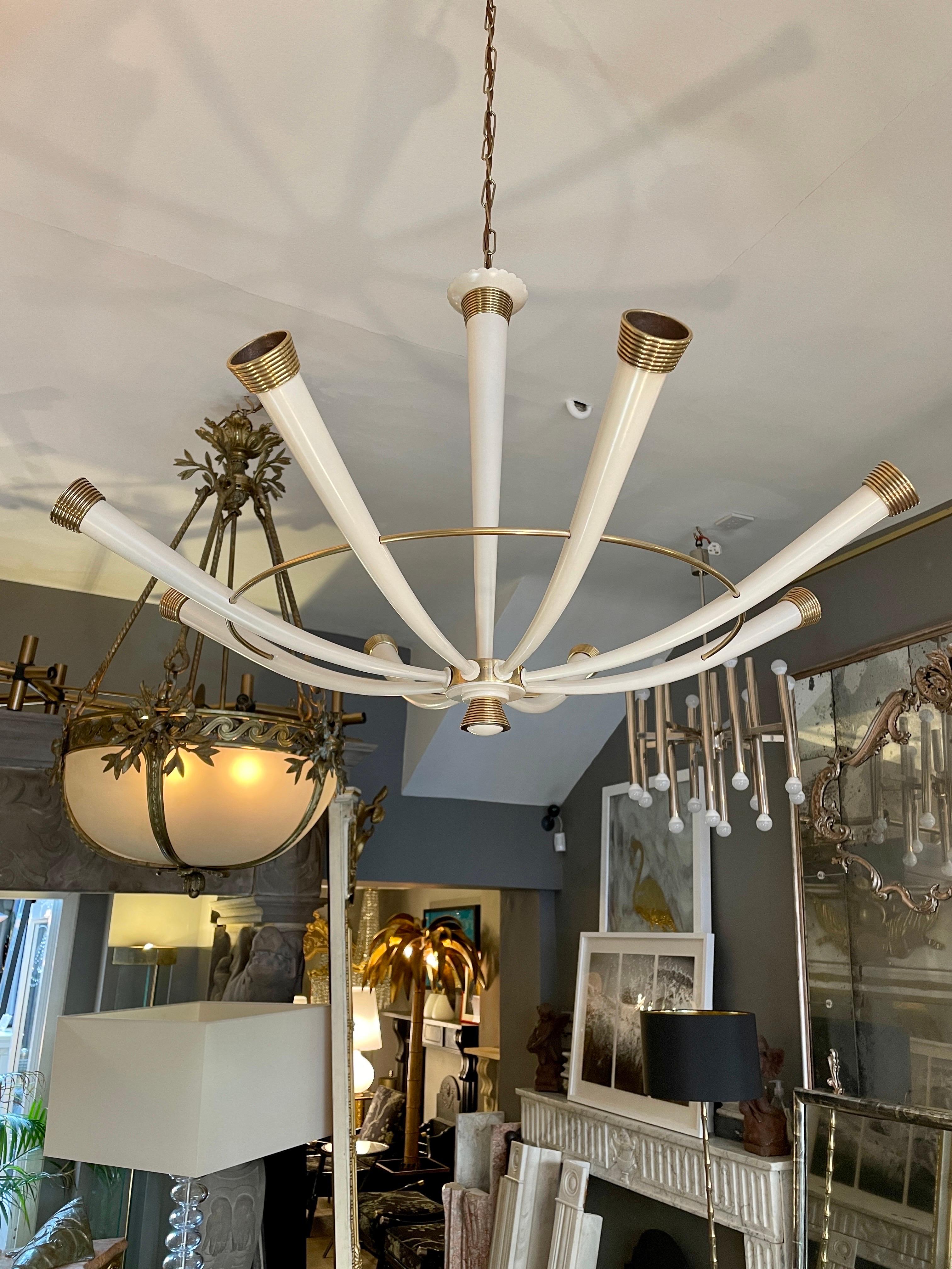 A large Italian Mid century chandelier in Brass with Ivory white painted arms and stem. the tapered centre stem supporting eight arms with a brass circular ring support the accents in ribbed brass. Completely restored, with fresh paint and patinated