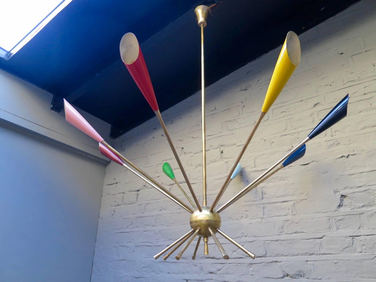 A vibrant multicolored and brass sputnik chandelier, from the Italian midcentury period. The eight arms supported from a central sphere and each ending in a colored bulb holder. Rewired and restored with detracting from its age.